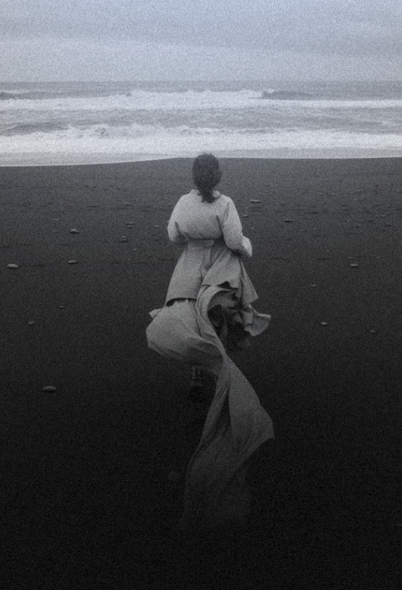 Woman walking across a dark landscape