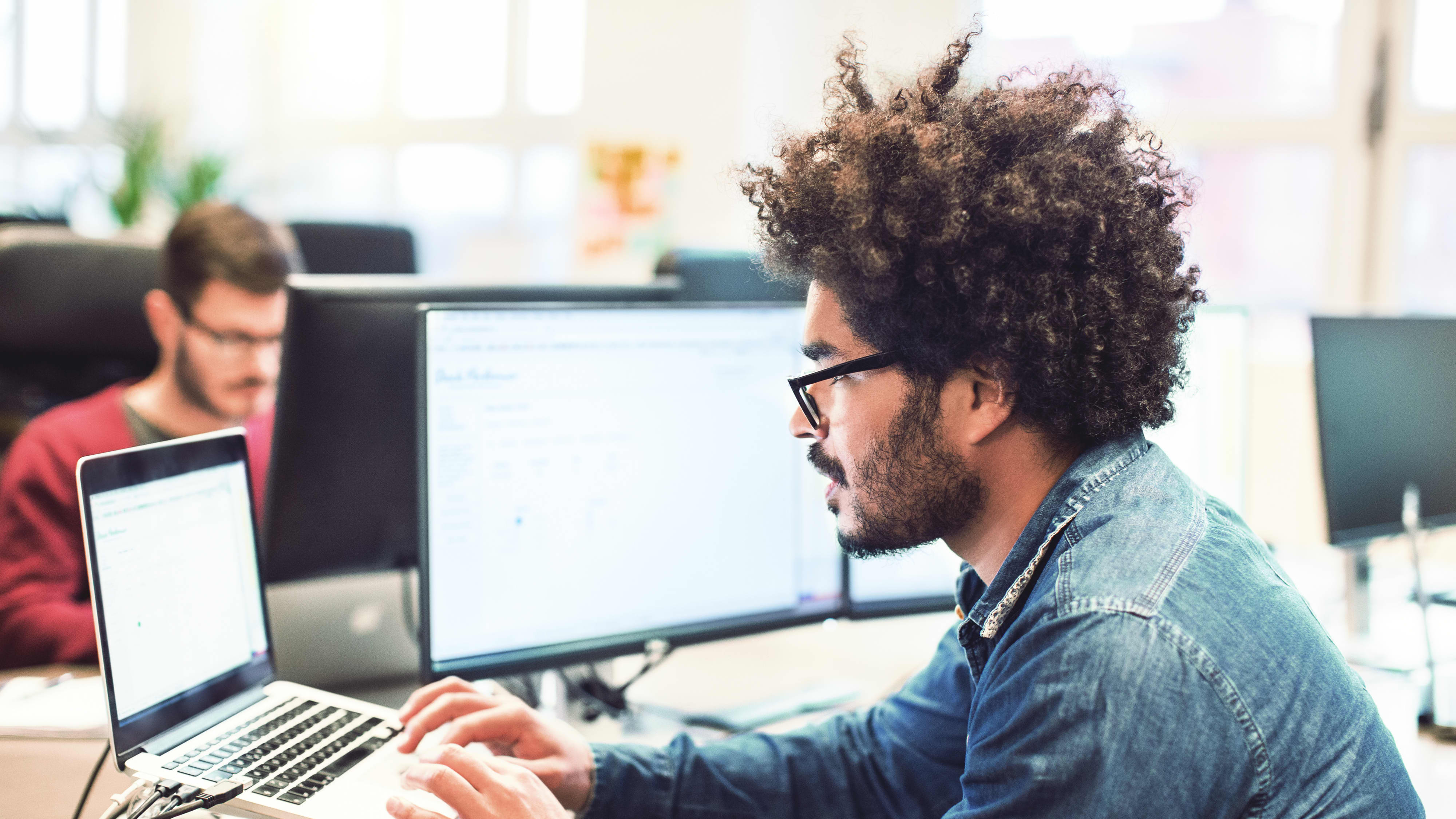 Mann mit Afro Frisur Arbeiten an seinem Schreibtisch
