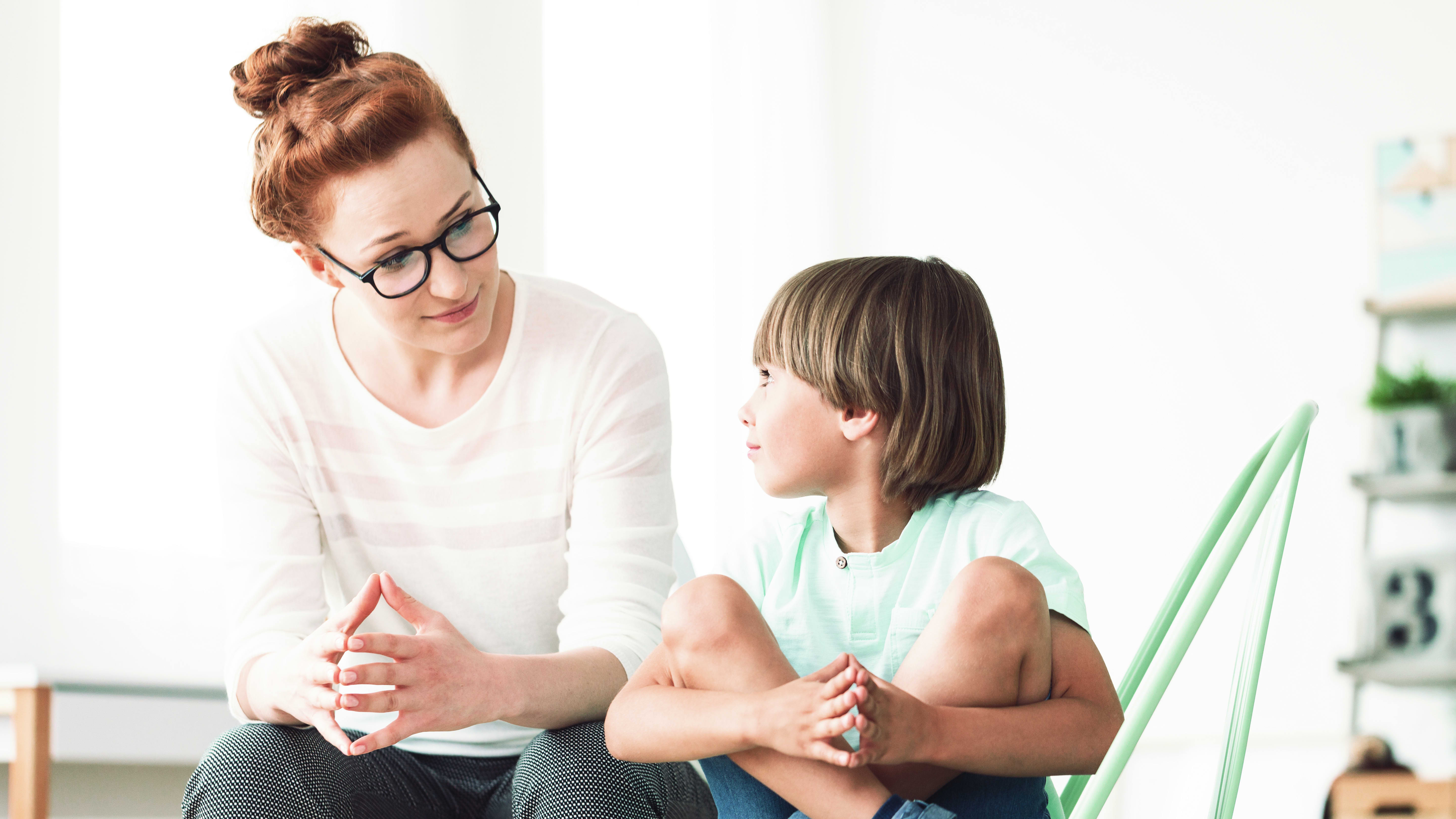 Psychologin spricht mit kleinem Jungen