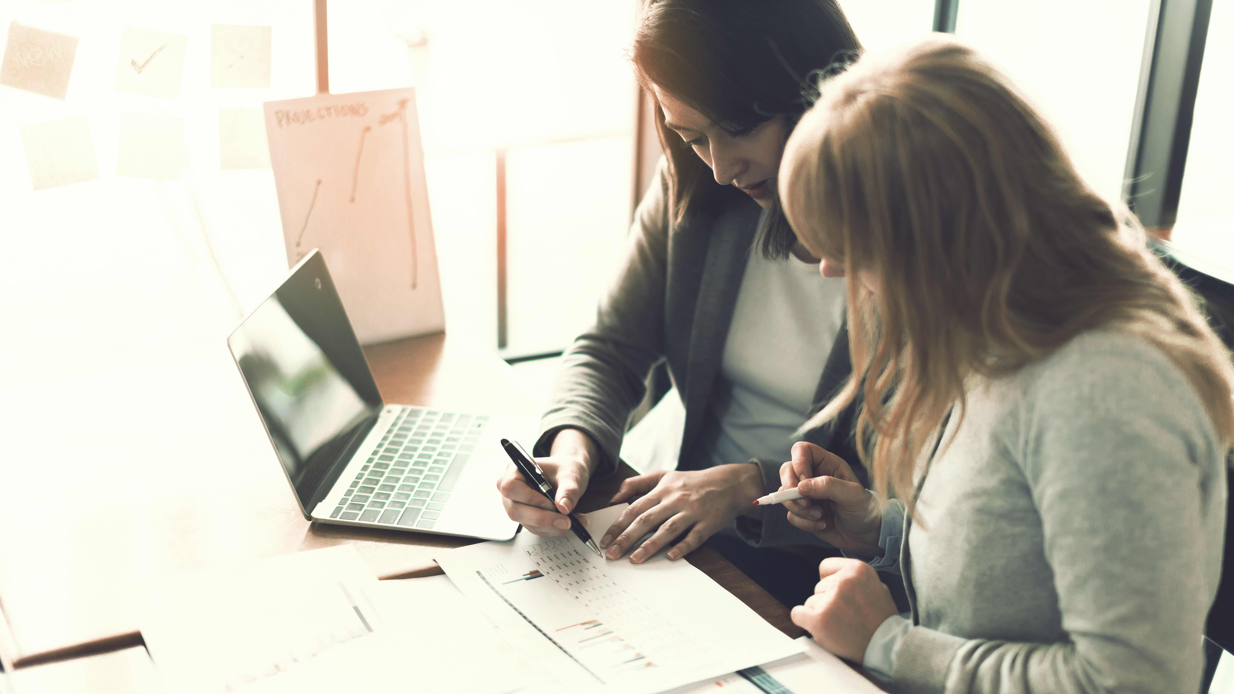 Frauen arbeiten gemeinsam an Laptop