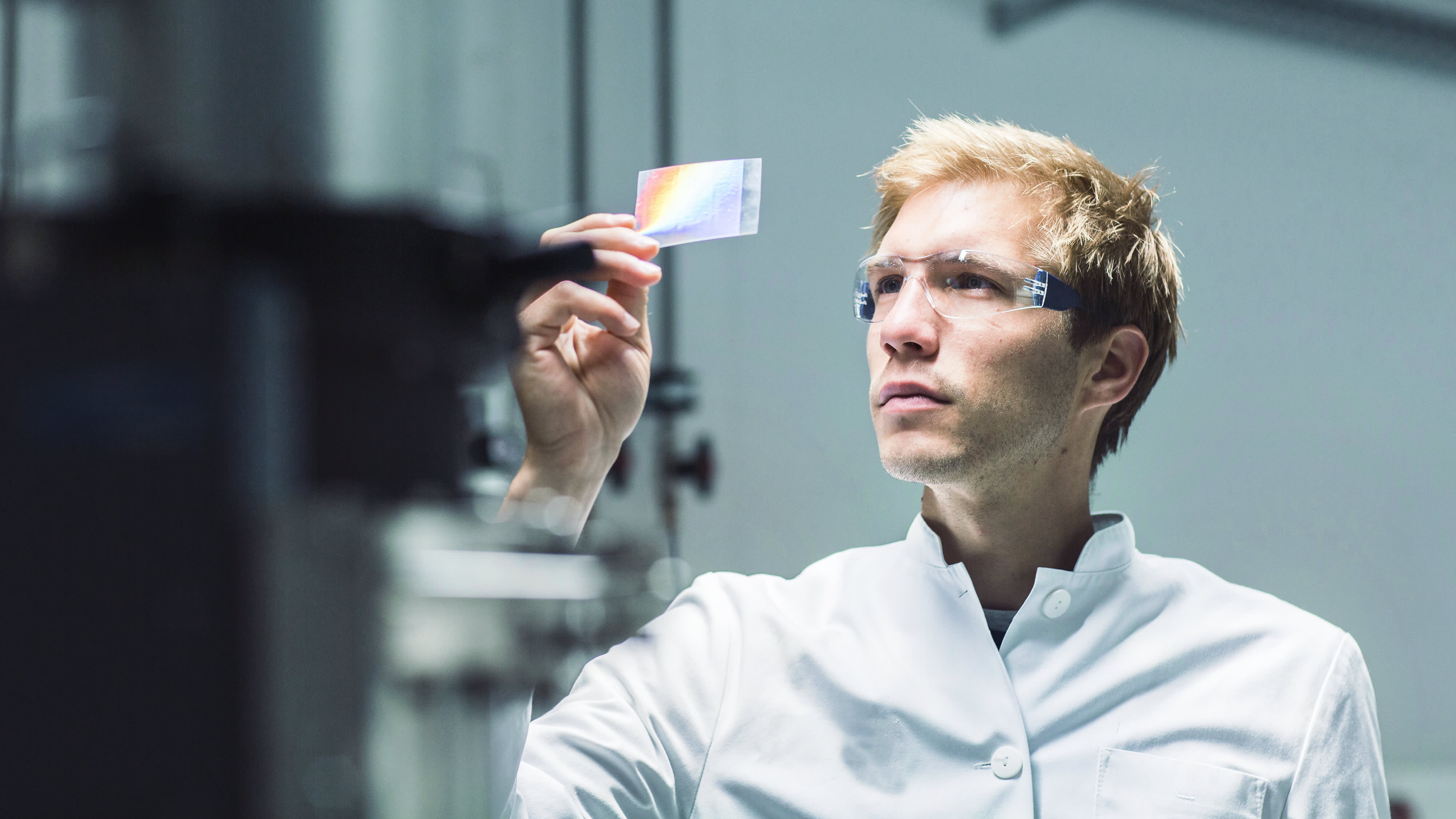 Male scientist analysing microscope slide in laboratory
