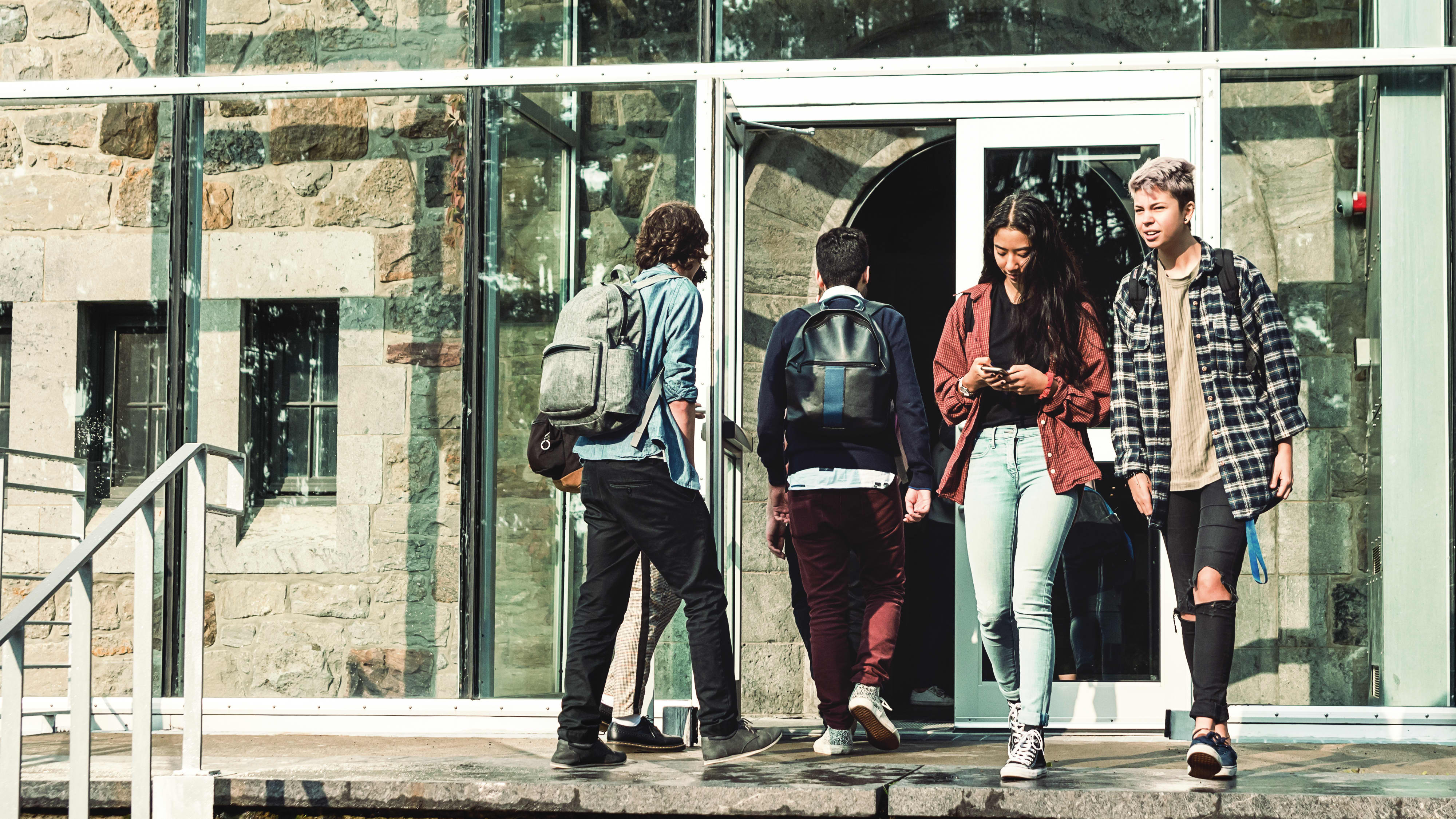 Multi-ethnischen Gruppe von Studenten vor Hochschule Universität Eingang.