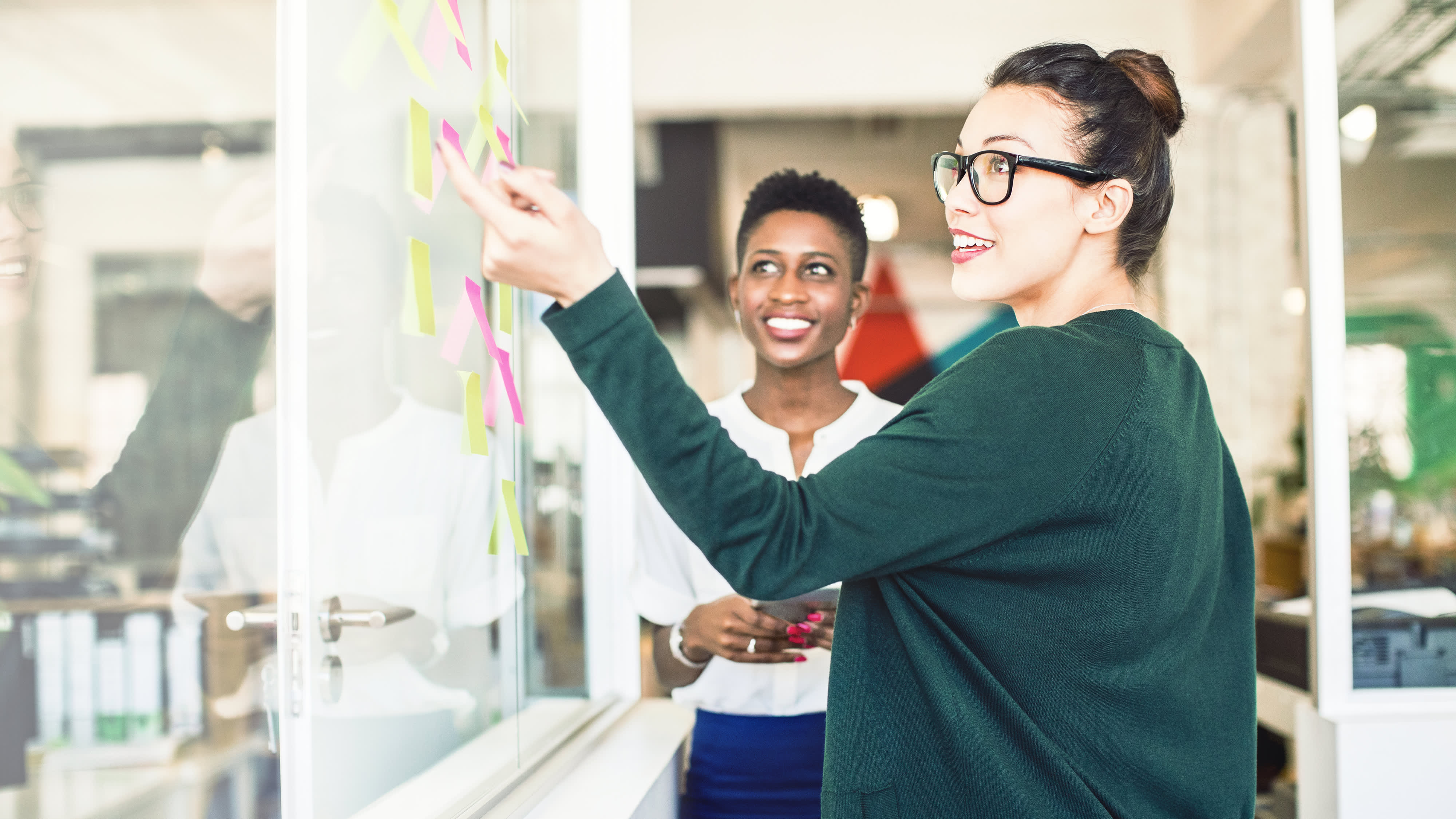 Geschäftsfrauen, die Überprüfung der Ideen zur Glaswand