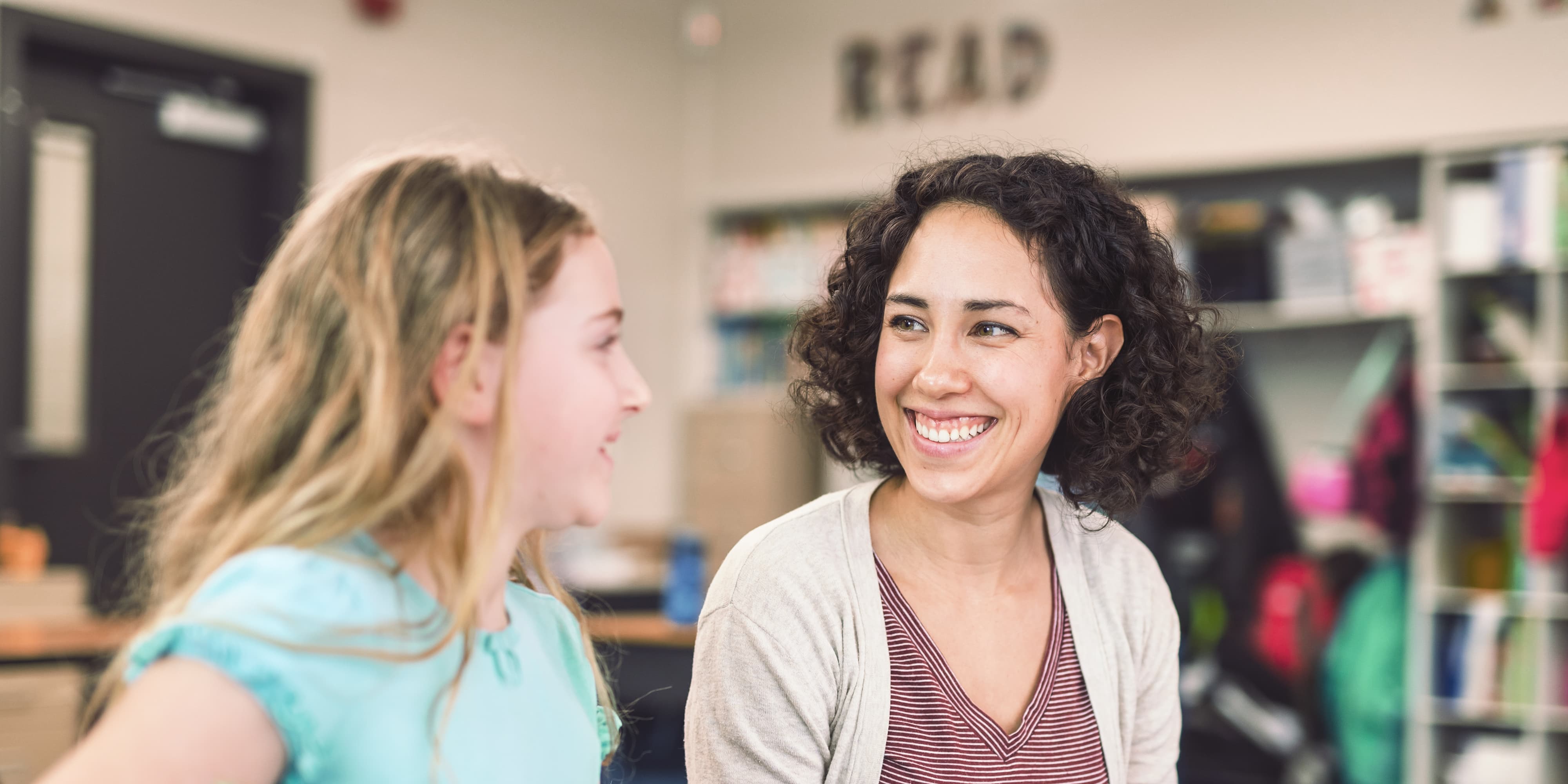 Lehrerin hilft einer Viertklässlerin in ihrem Klassenzimmer