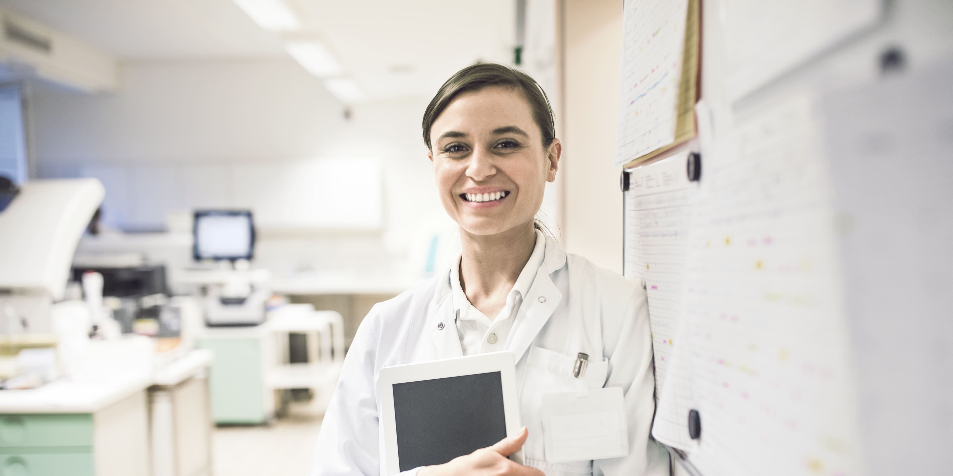 Lächelnde Wissenschaftlerin hält digital-Tablette