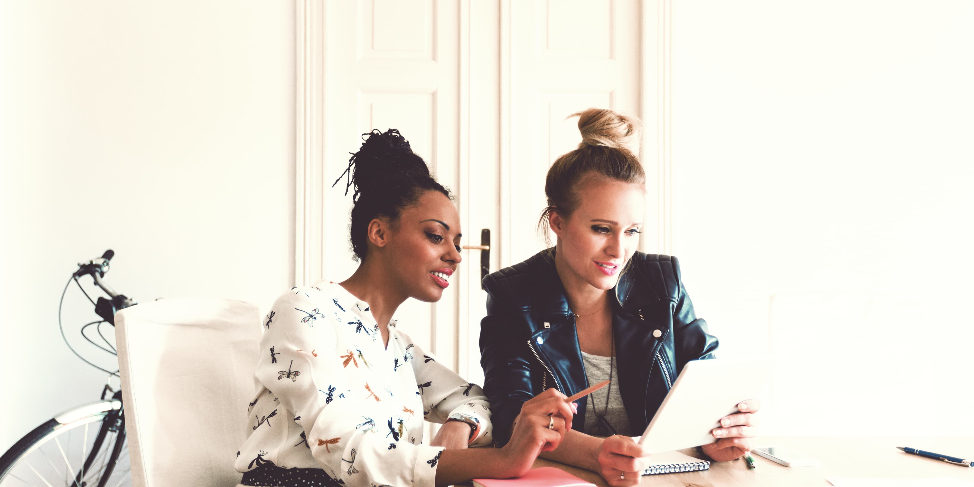 Zwei Frauen arbeiten an Tablet