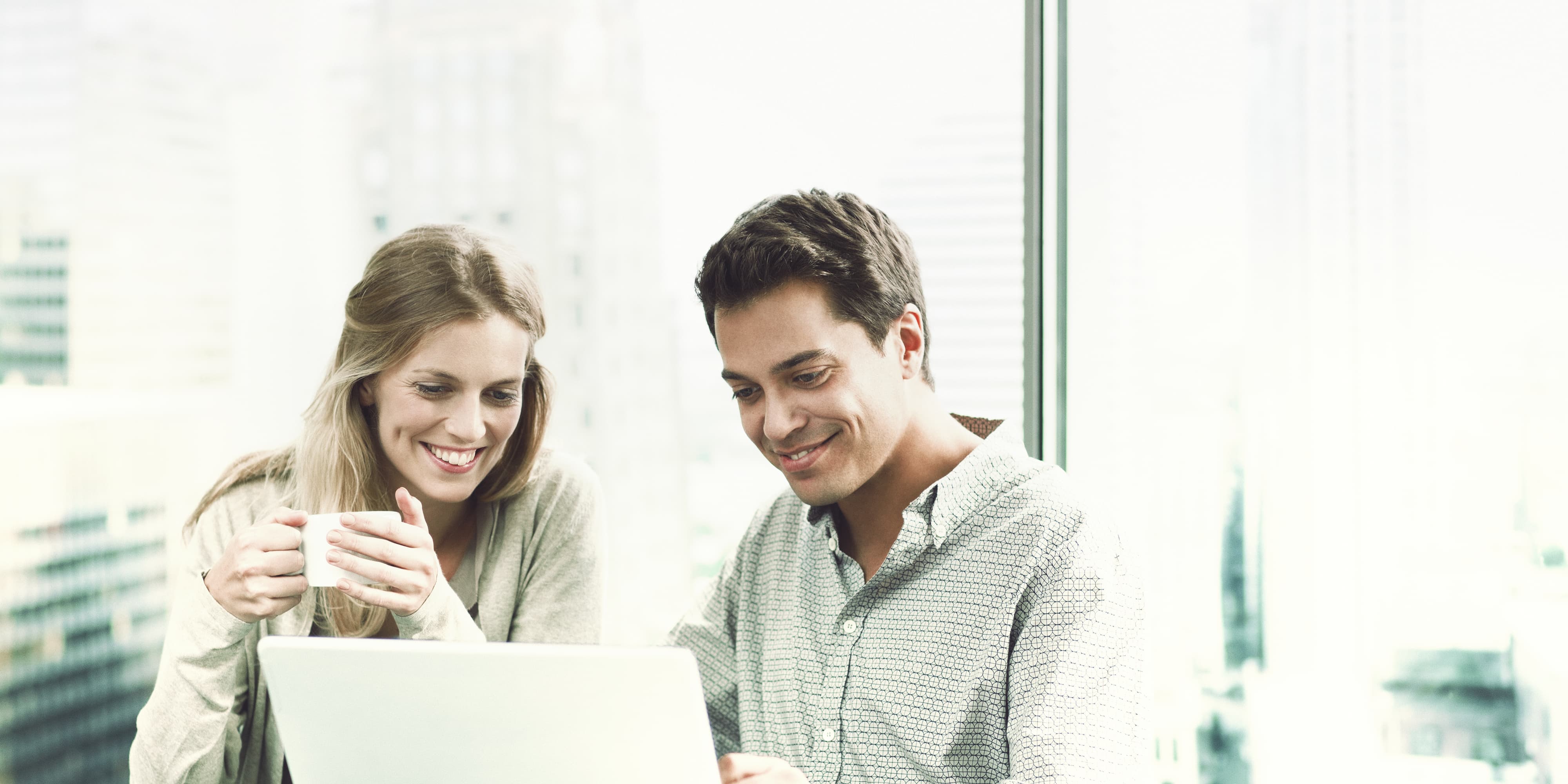 Mann und Frau arbeiten vor Laptop