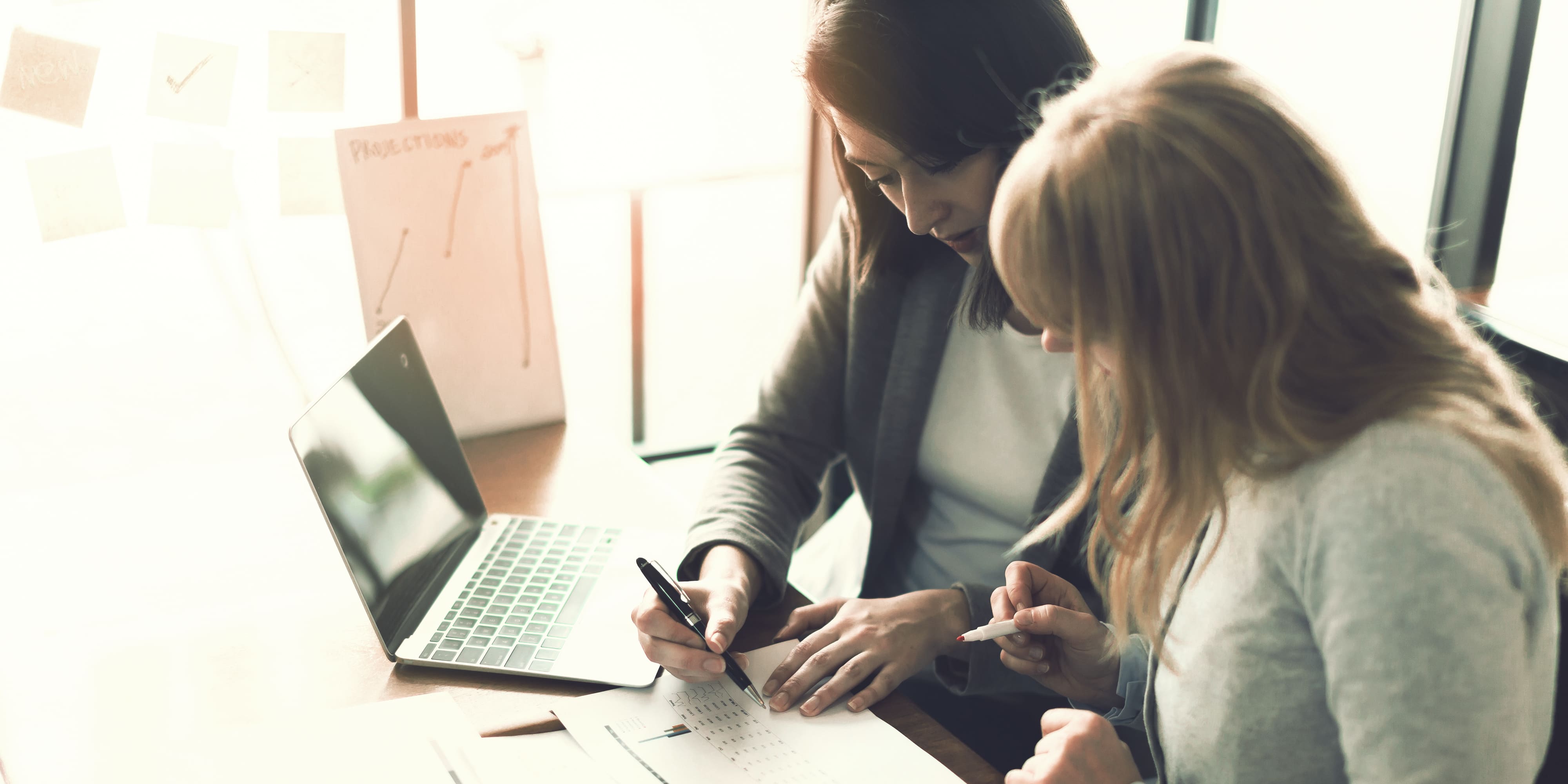 Frauen arbeiten gemeinsam an Laptop