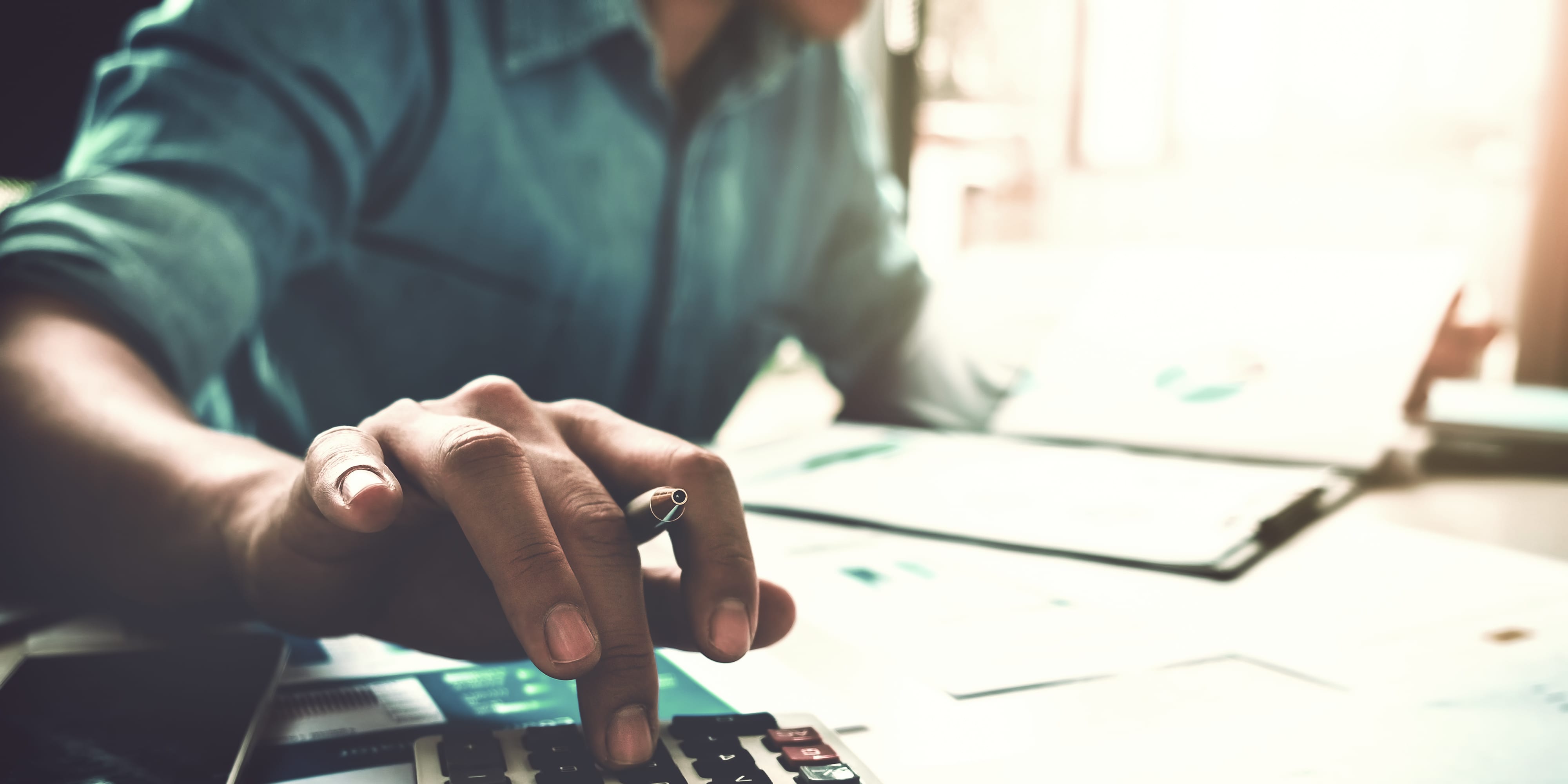 Mann arbeitet mit Taschenrechner