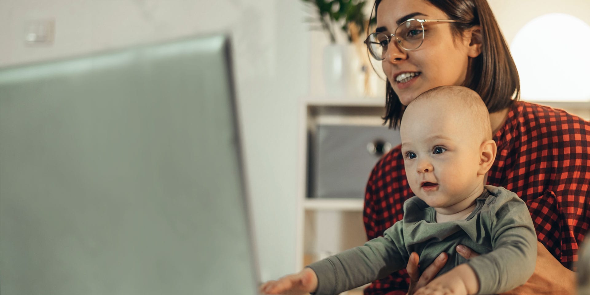 Flexibles Studieren mit Kind - Studentin mit Baby vor dem Laptop