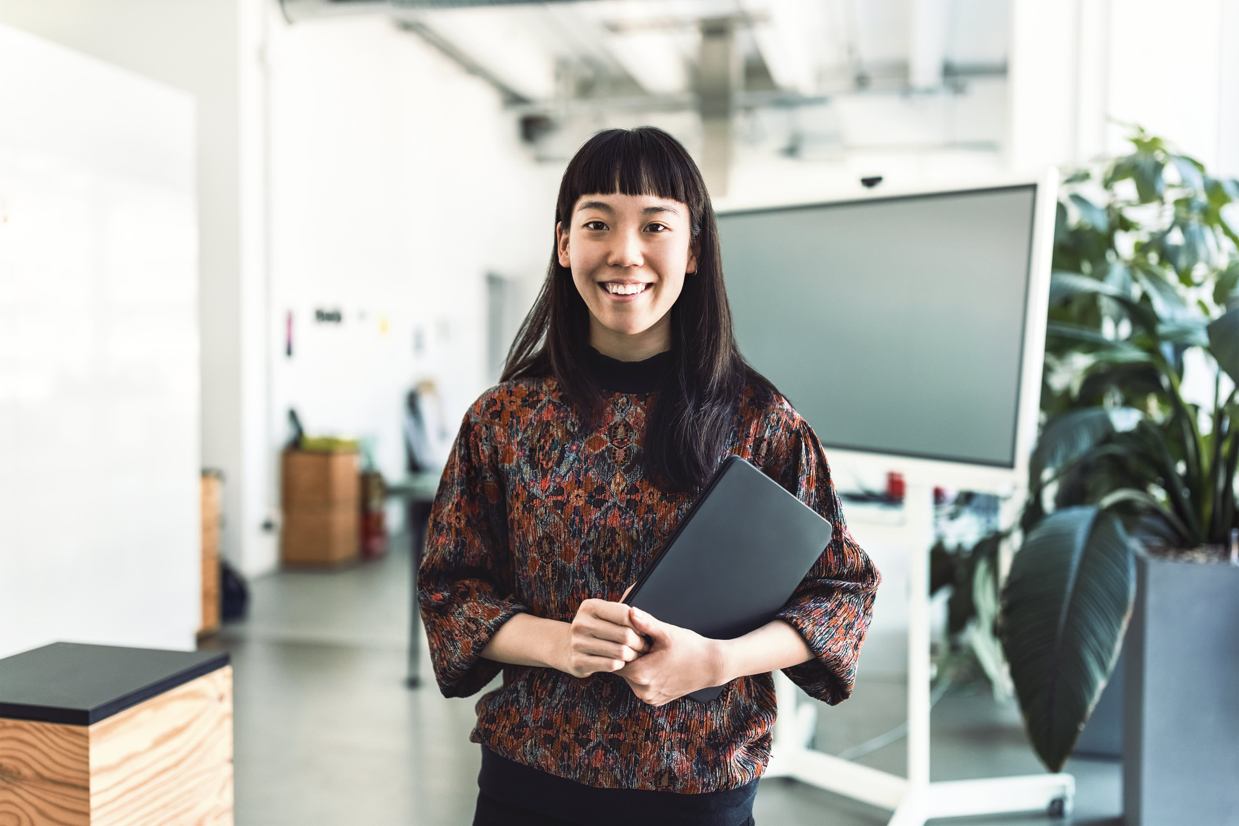 Smiling entrepreneur standing in modern office space