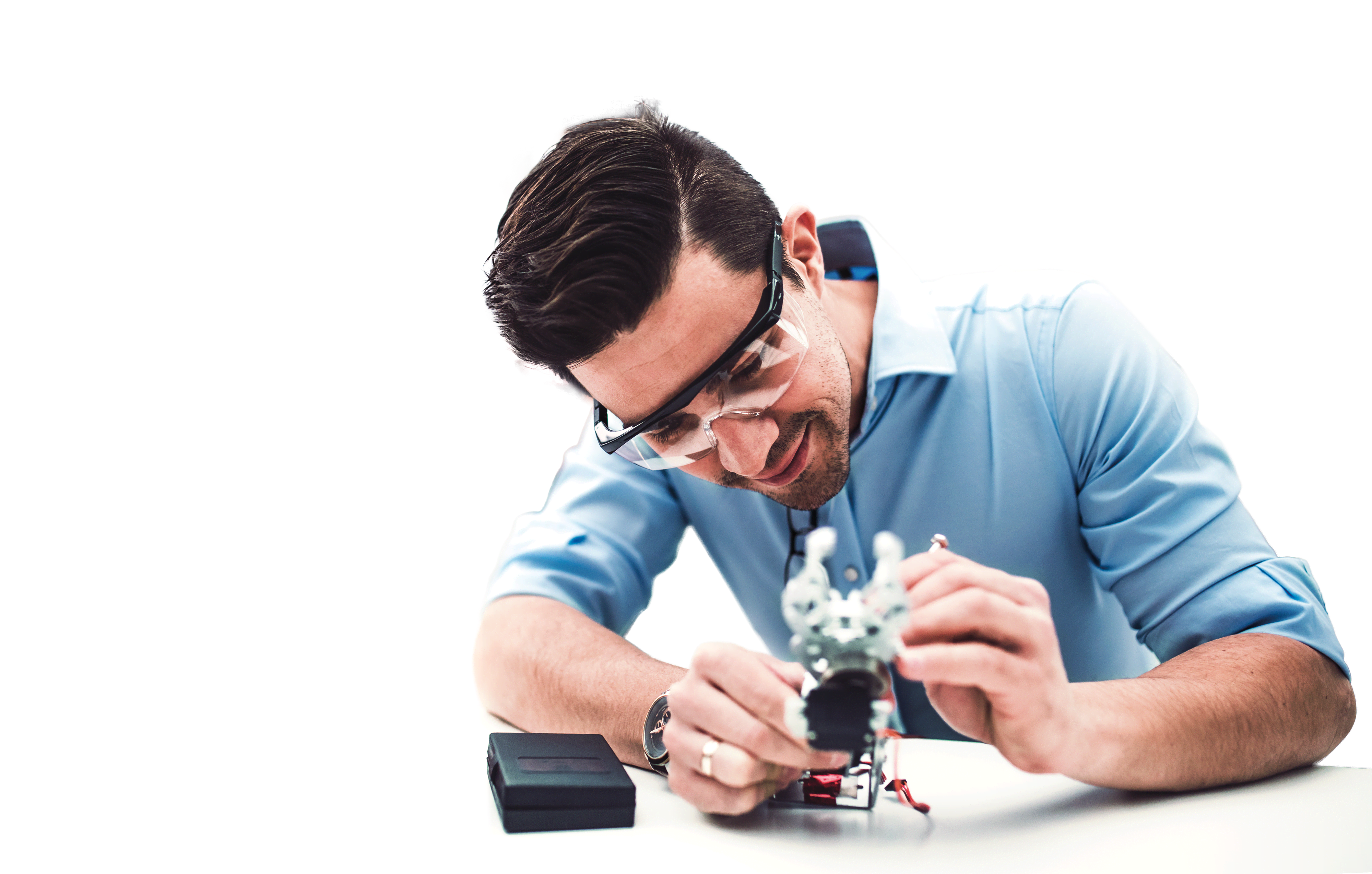 Ein junger Geschäftsmann oder Wissenschaftler mit robotischer Hand, die im Amt steht, arbeitet.