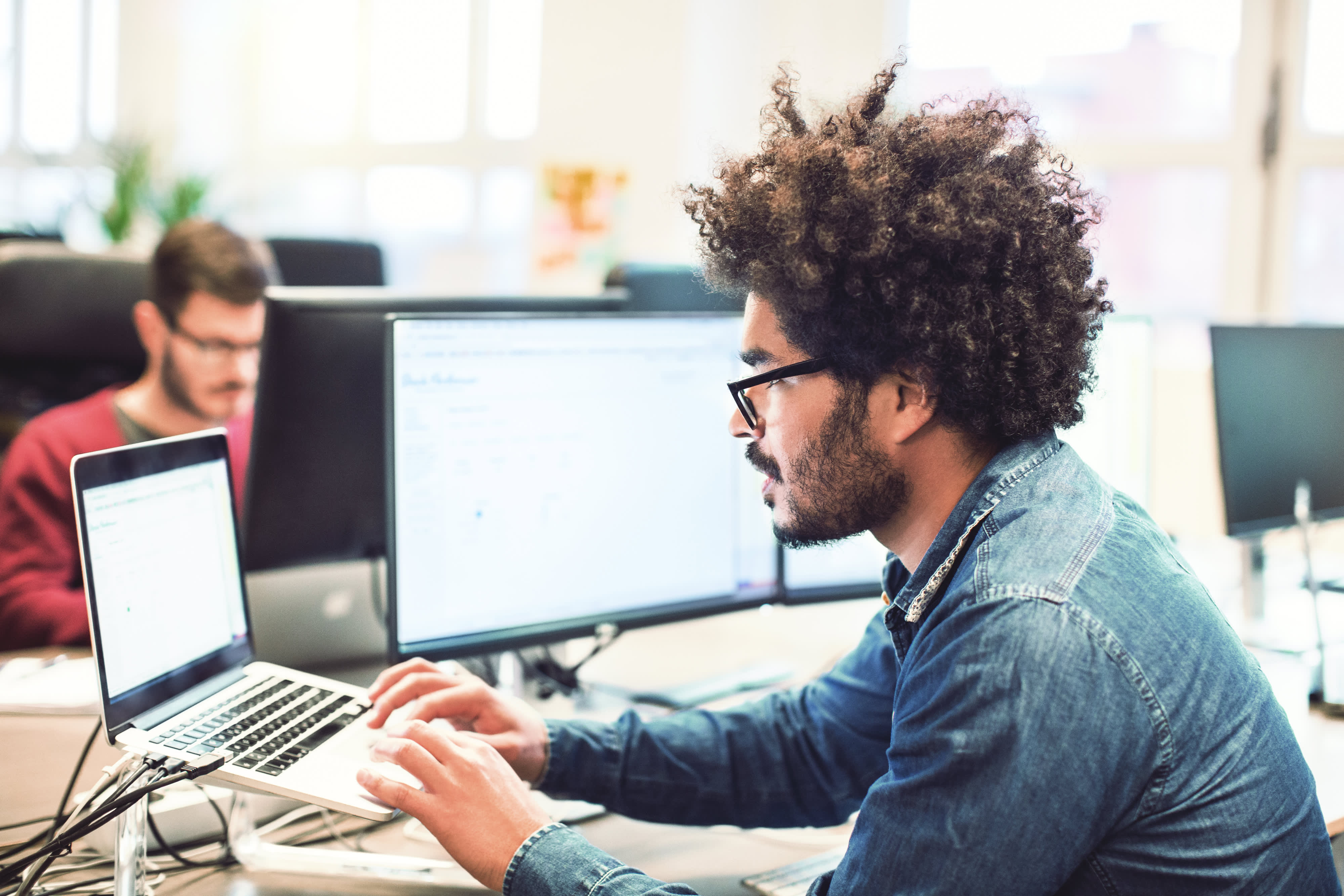 Mann mit Afro Frisur Arbeiten an seinem Schreibtisch