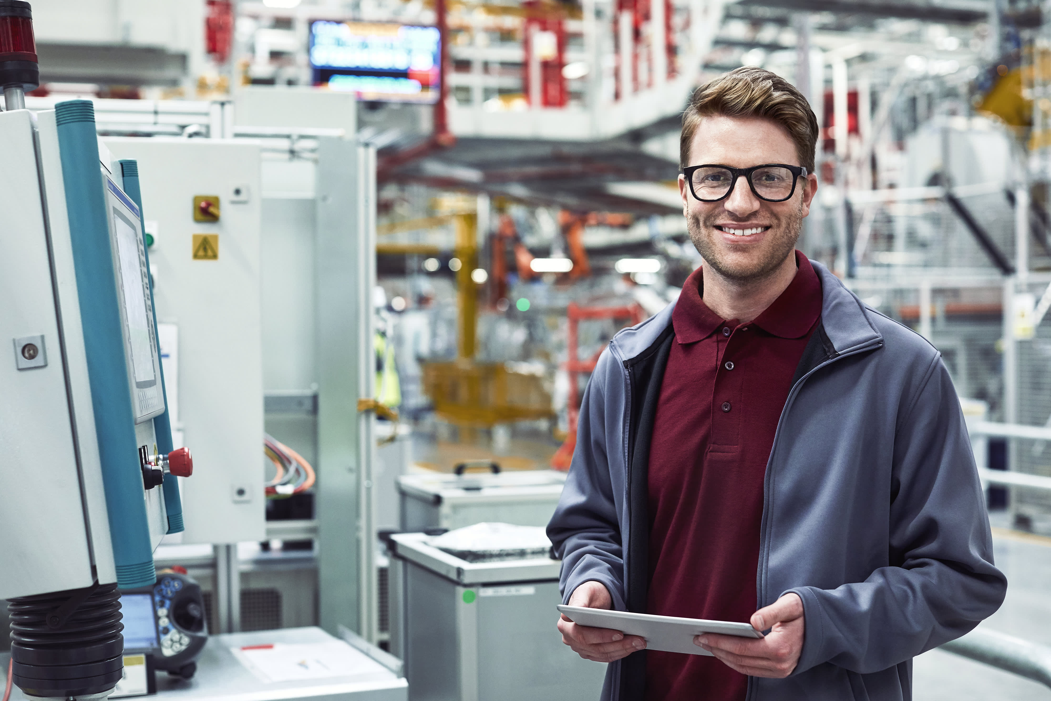 Männliche Ingenieur mit Tablet-pc im Automobilwerk