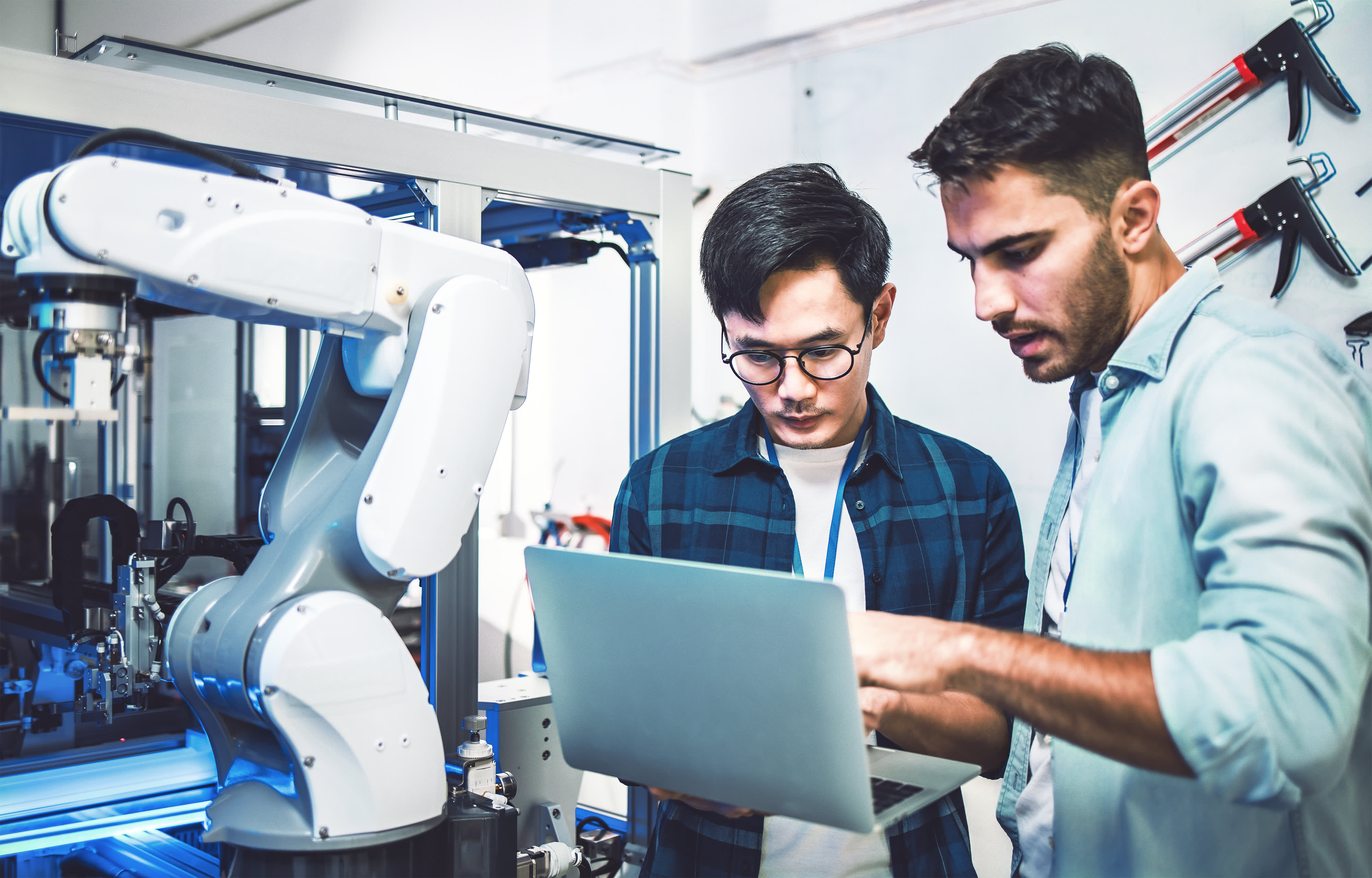 Ein Team von Ingenieuren führt ein Experiment mit Robotern durch. Nahaufnahme eines futuristischen Prothetikroboterarms, der von einem professionellen Entwicklungsingenieur getestet wird