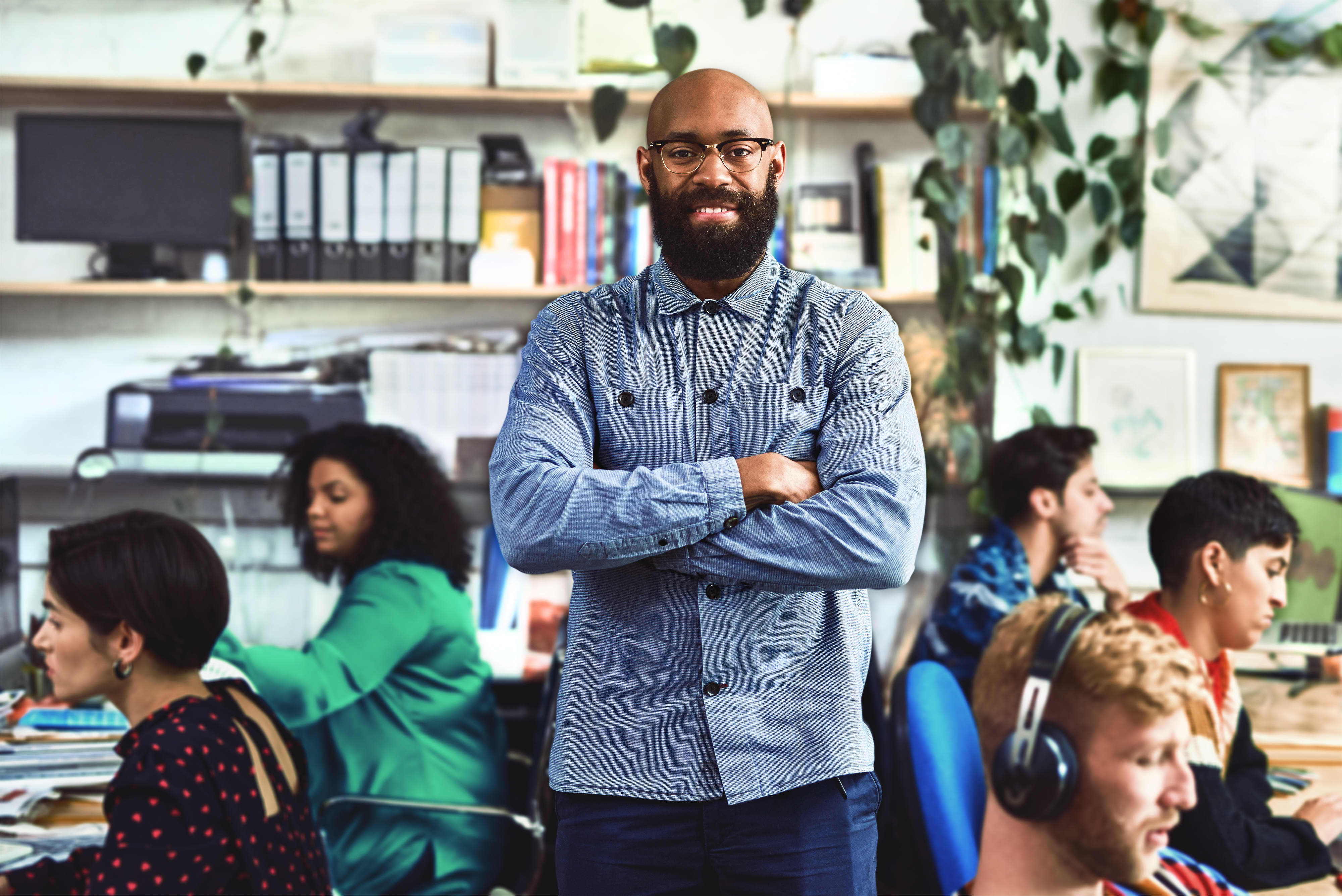 Entrepreneur in busy office smiling at camera