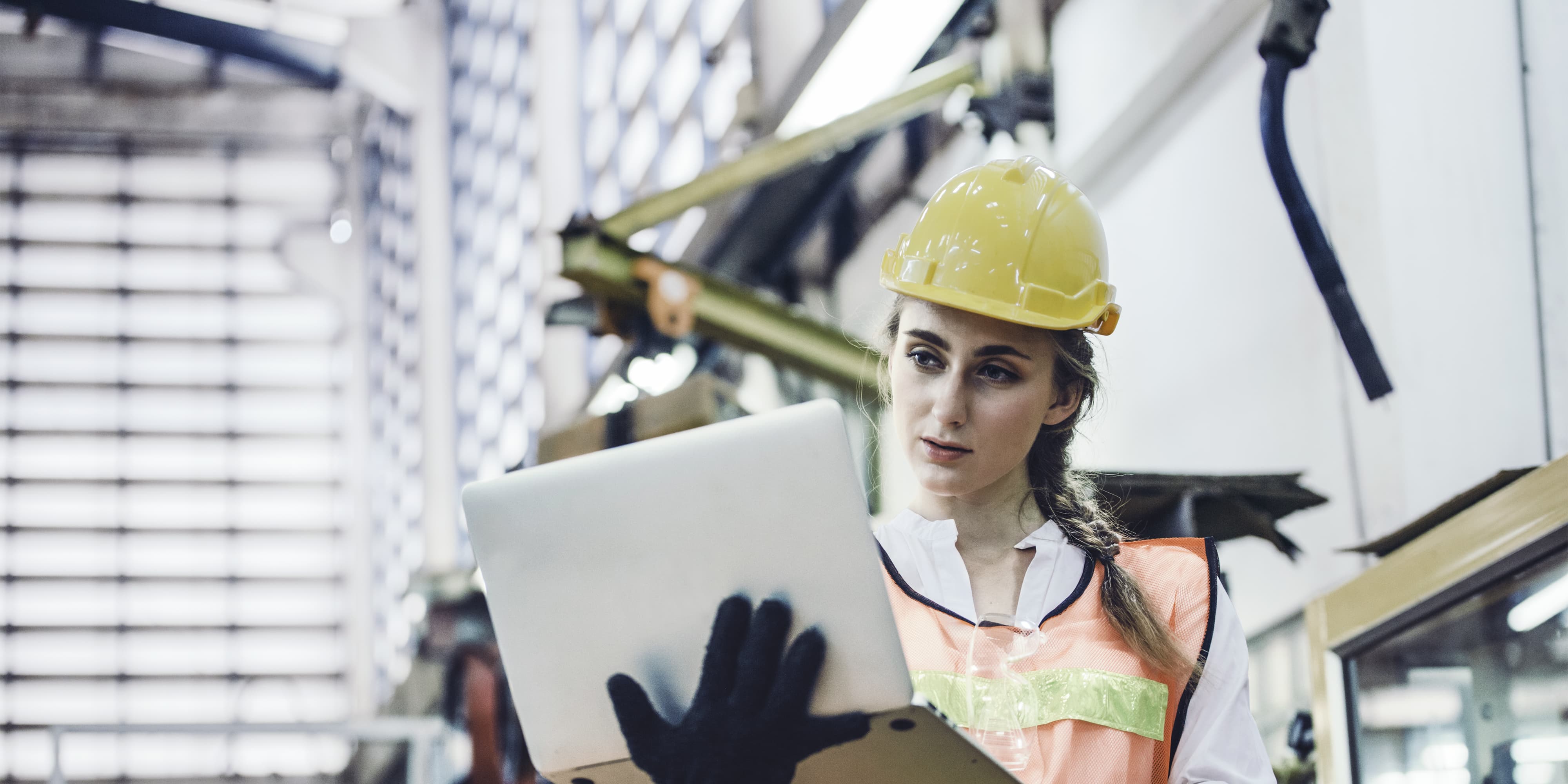 Frau Industrieingenieurin oder Technikerin in Harthelm und Uniform mit Laptop-Kontrolle auf Roboter-Armmaschine. Frau arbeiten hart in der Schwertechnologie Erfindung Industrie Herstellung Fabrik