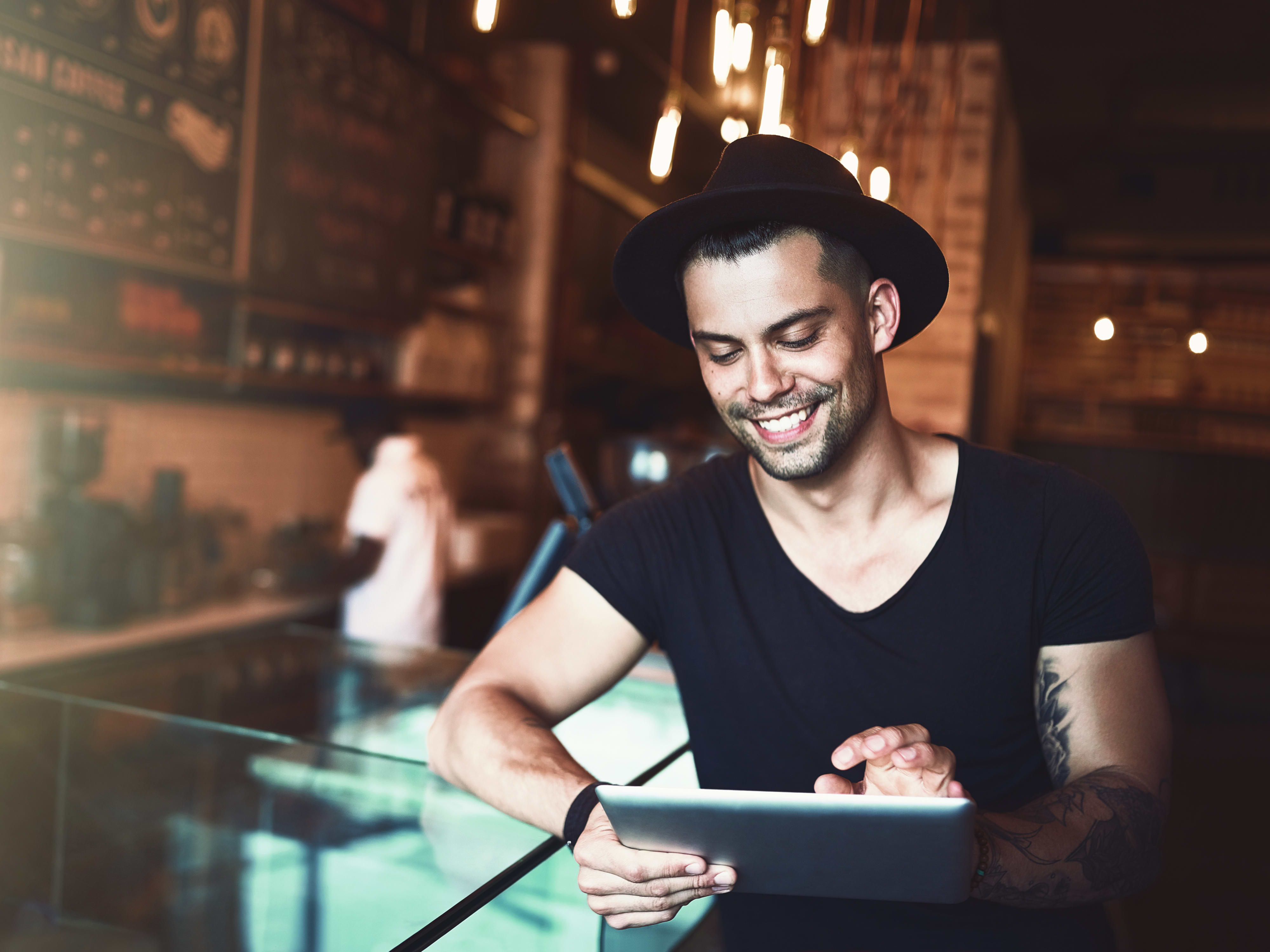 Student sitzt mit IPad in einem Café und lernt