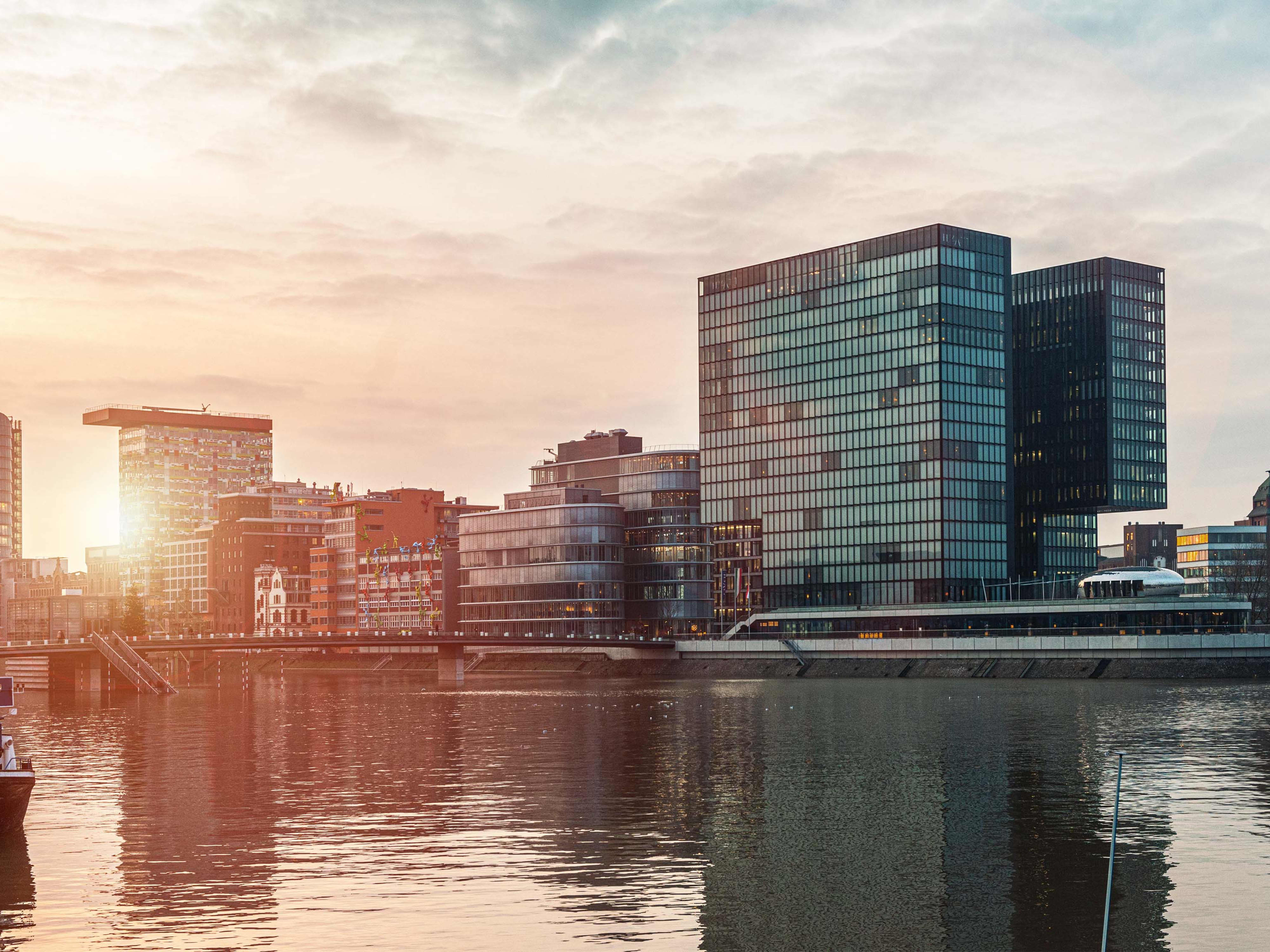 Titelbild der Infoseite "Duales Studium Immobilienwirtschaft in NRW": Großstadt in NRW mit Wolkenkratzern direkt am Wasser