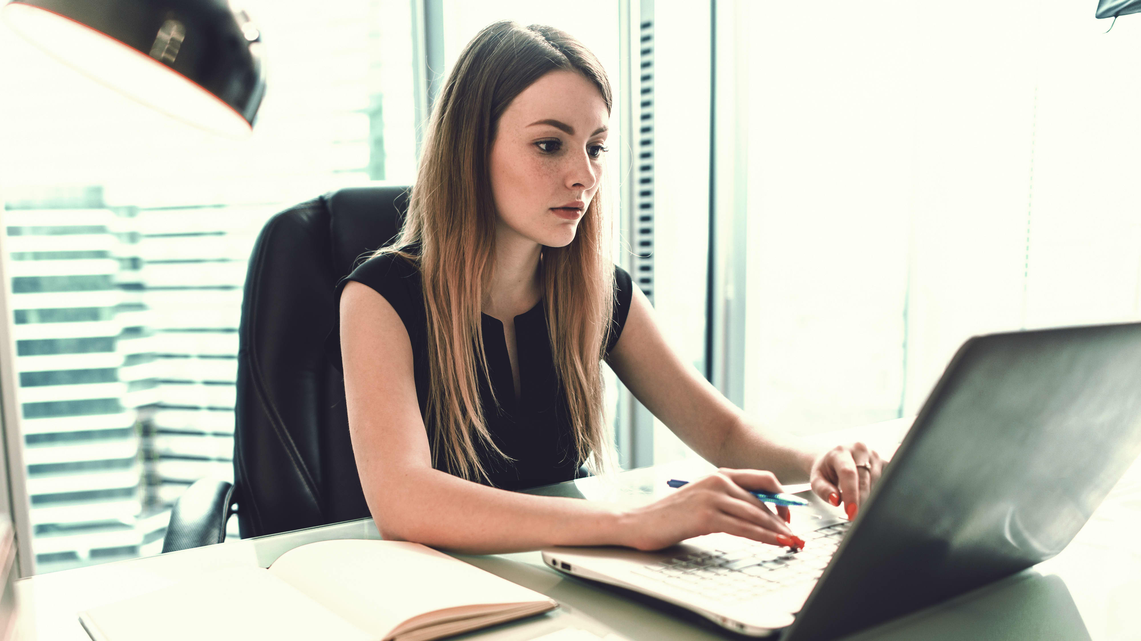 Wirtschaftsprüferin arbeitet am Laptop im Büro