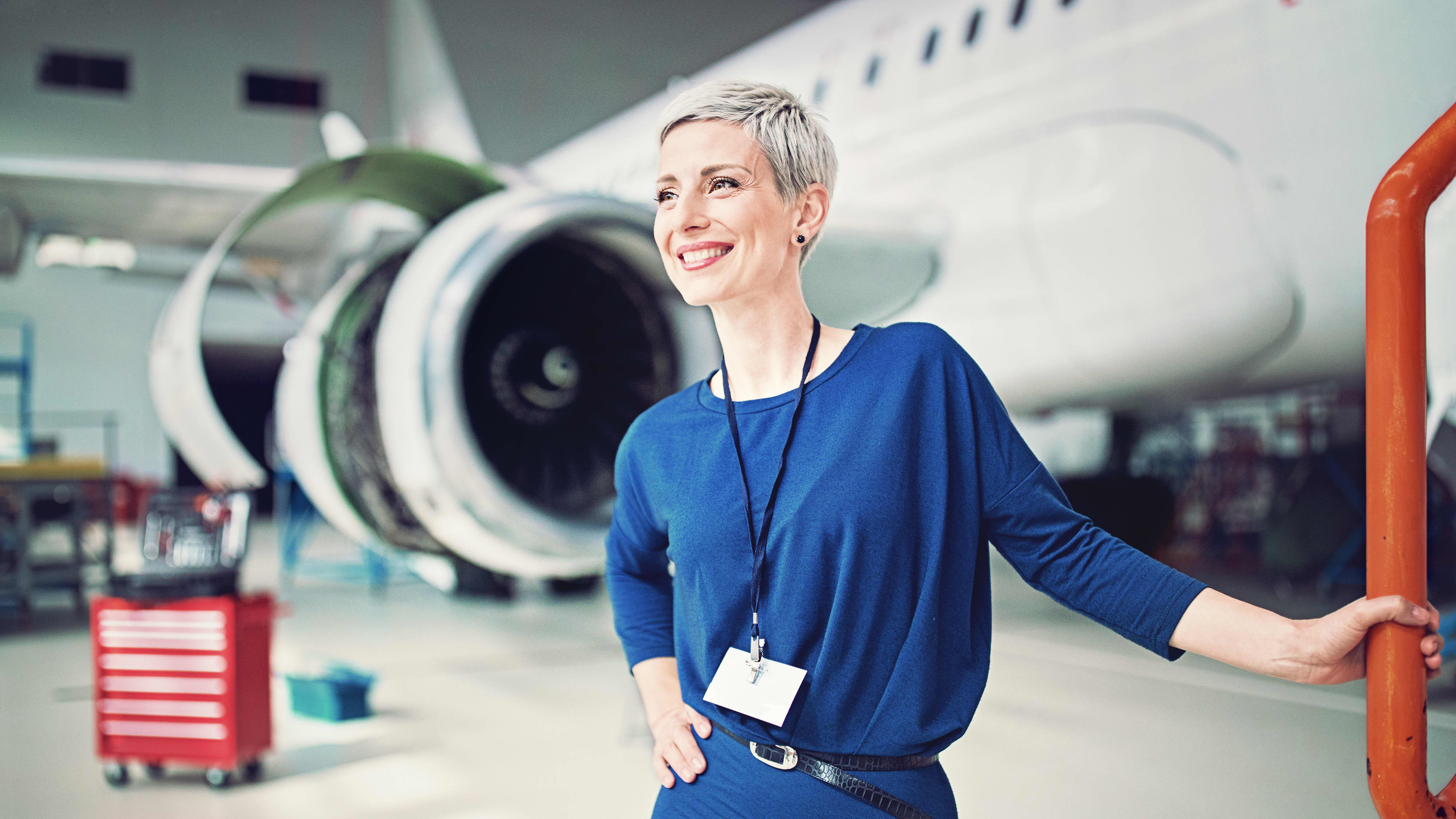 Titelbild für Infoseite “Bachelor Aviation Management”: Flughafenmitarbeiterin im Flugzeug Hangar
