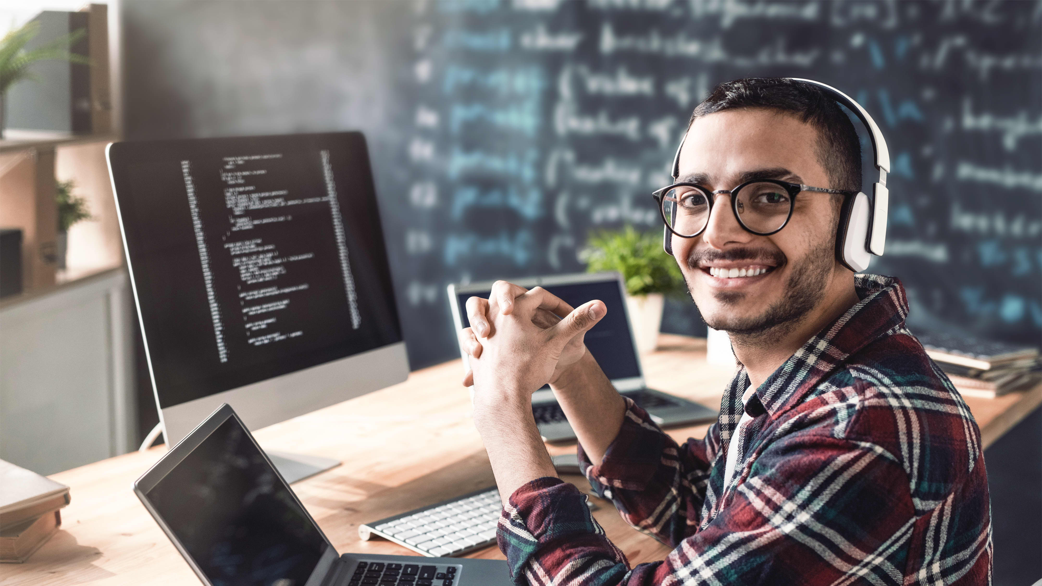 Titelbild für Infoseite “Bachelor Cyber Security”: Student mit Kopfhörer arbeitet am Laptop