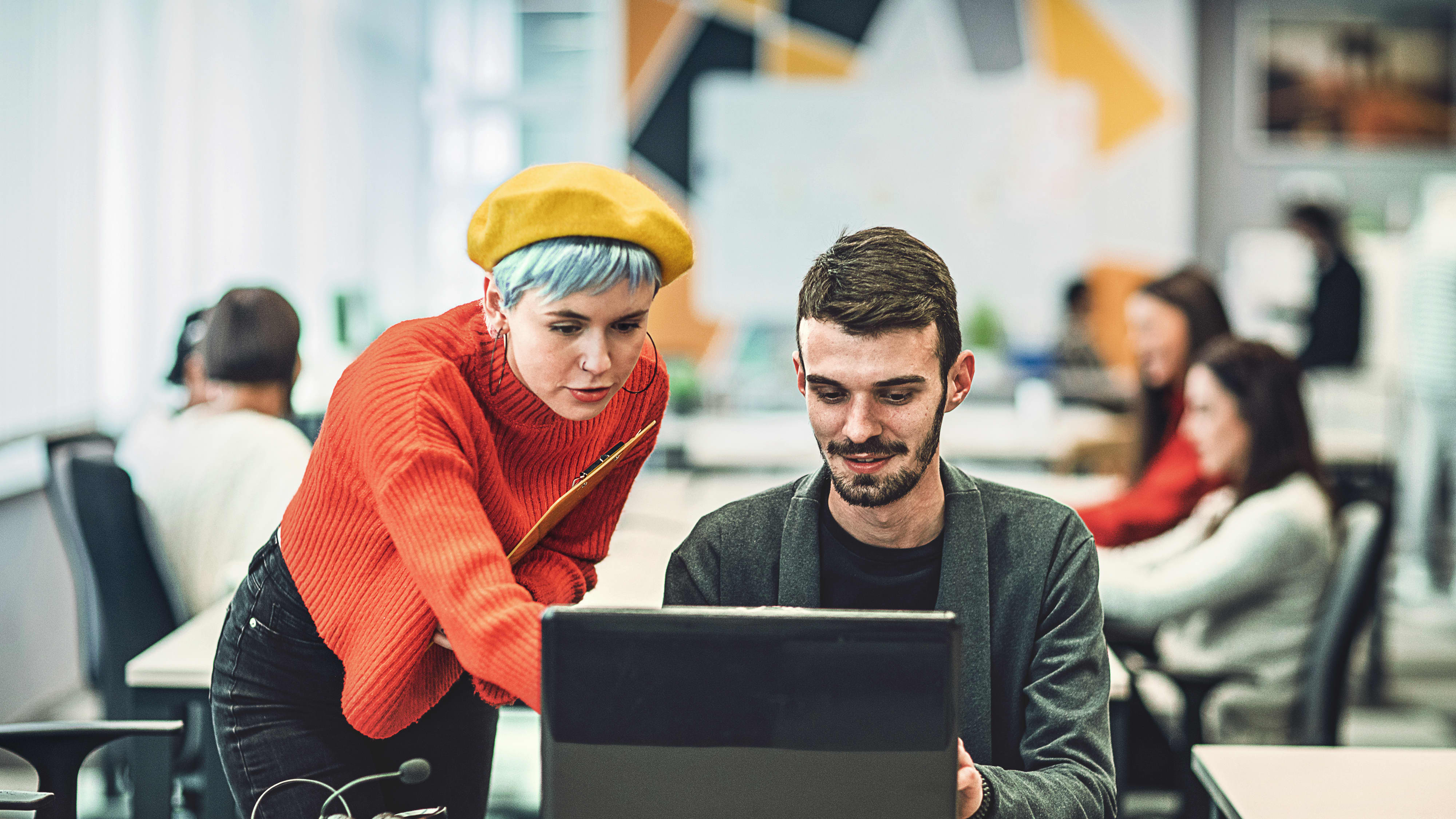Titelbild für Infoseite “Bachelor Personalmanagement”: Zwei Personalmanager schauen zusammen auf Bildschirm