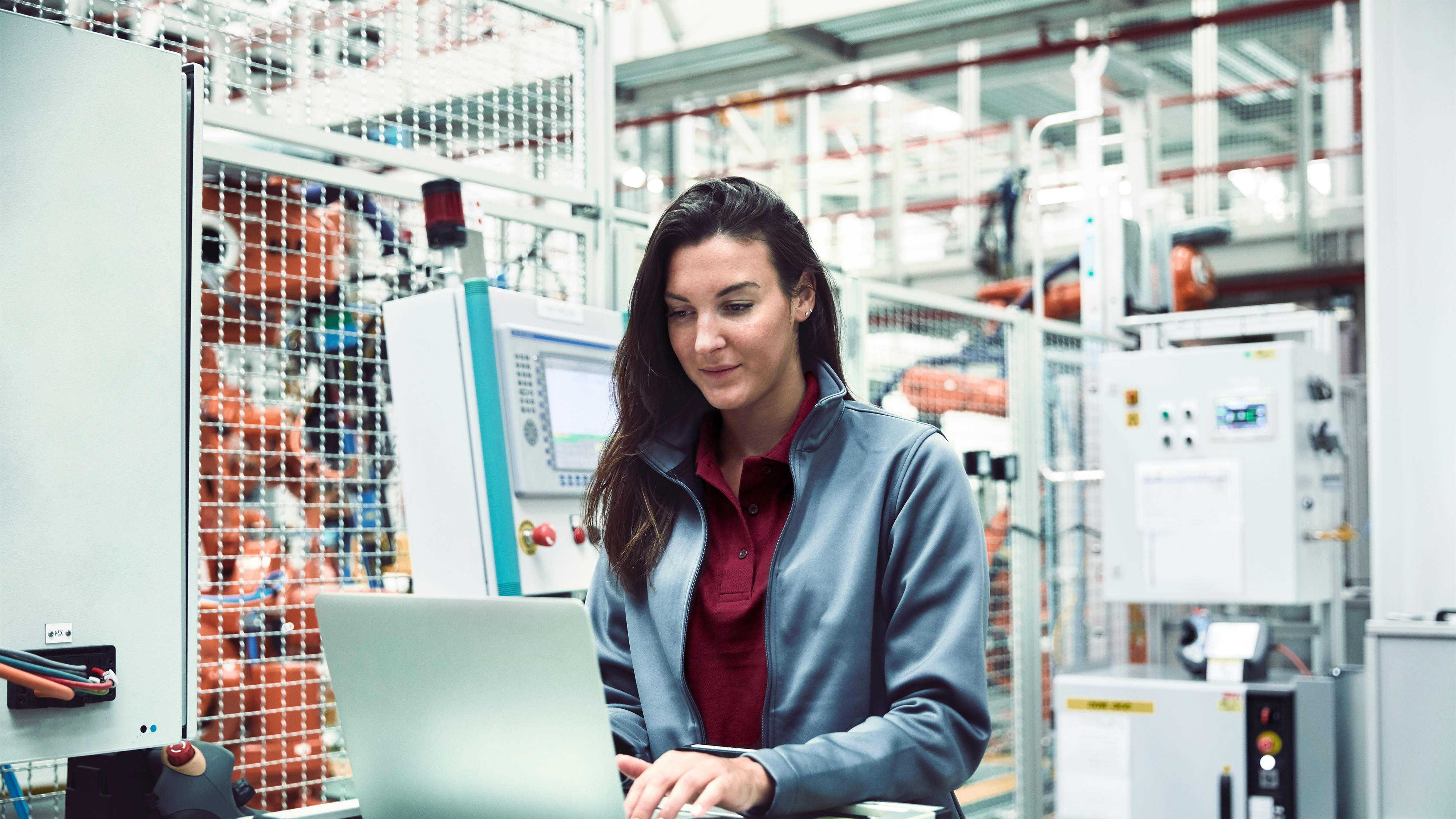Titelbild für Infoseite “Bachelor Wirtschaftsingenieurwesen Industrie 4.0”: Ingenieurin mit Laptop in der Automobilindustrie