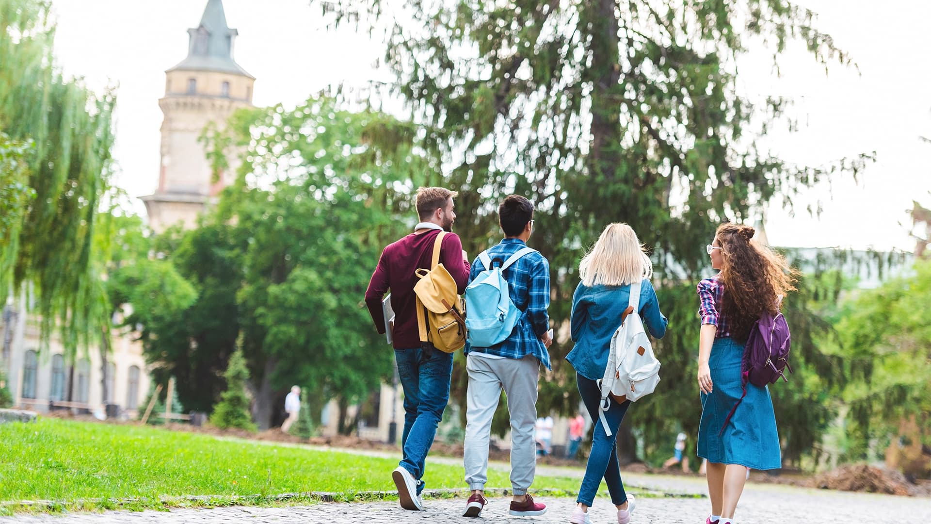 Group of four students walking in the campus