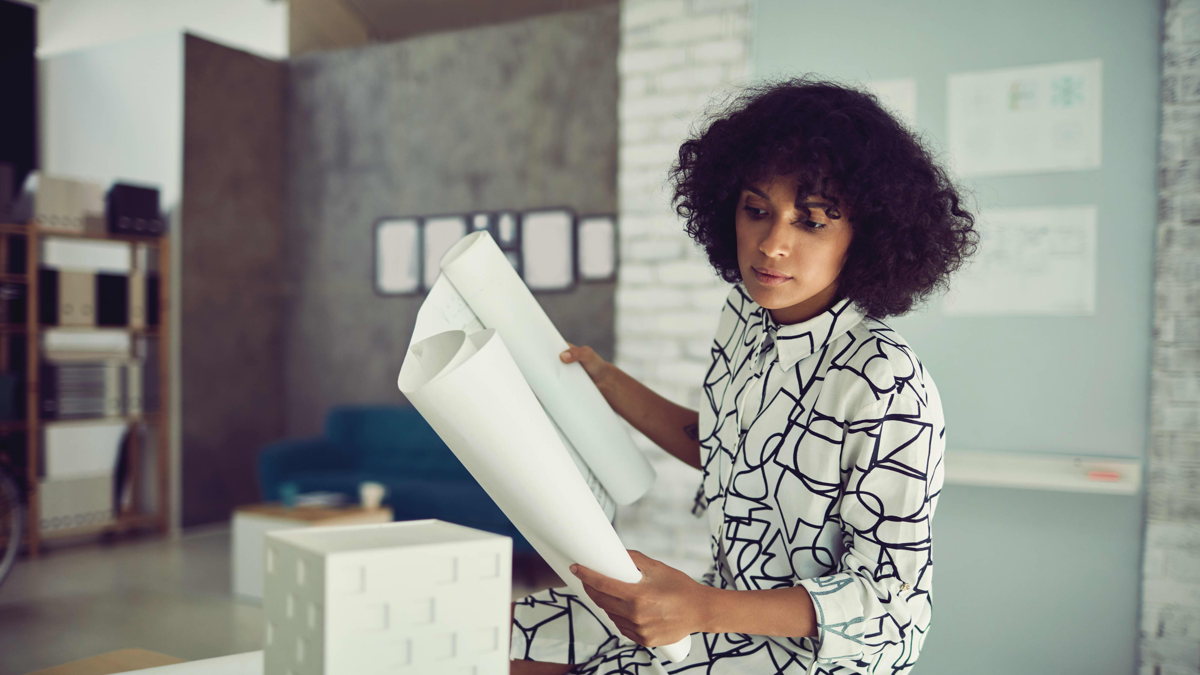 Titelbild für Infoseite “Bachelor Architektur”: Studentin arbeitet an Bau-Modell