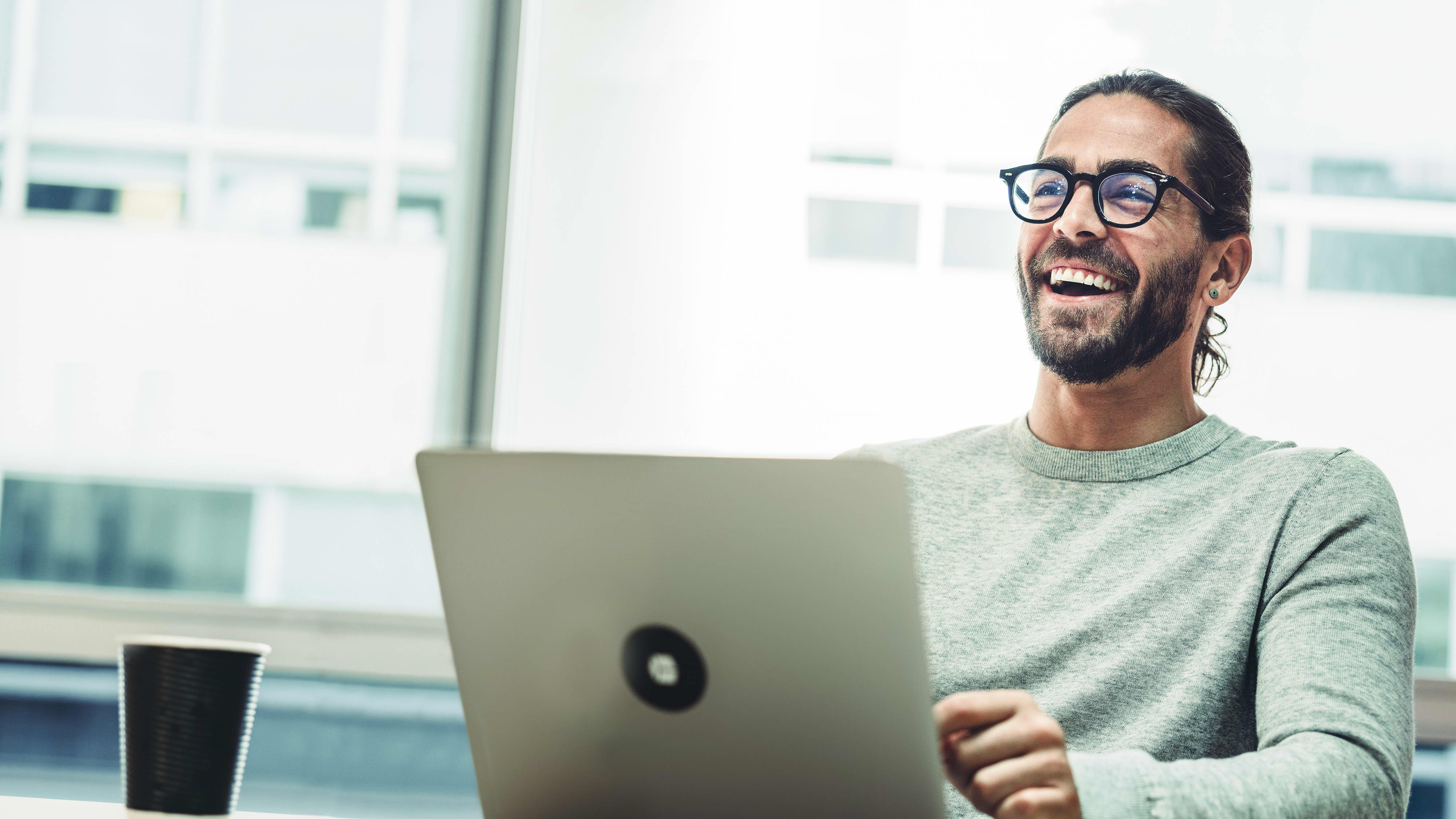 Titelbild für Infoseite “Master Growth Hacking for Entrepreneurs”: Growth Manager arbeitet am Laptop im Büro