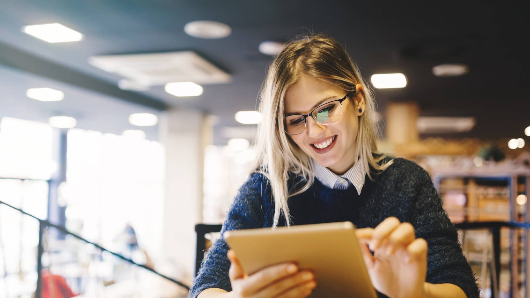 Studentin lernt mit Tablet in Bibliothek