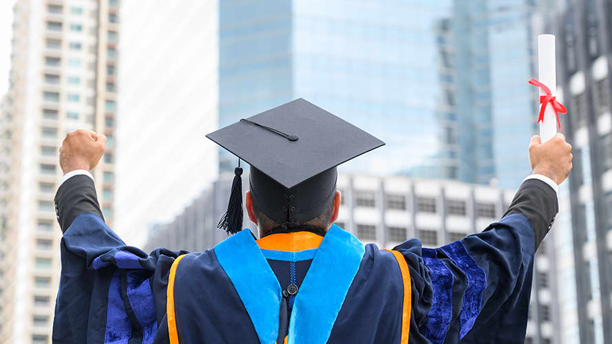 A university graduate holding their degree in celebration