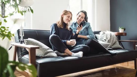 Zwei junge Frauen sitzen auf einer Couch, AI-generated
