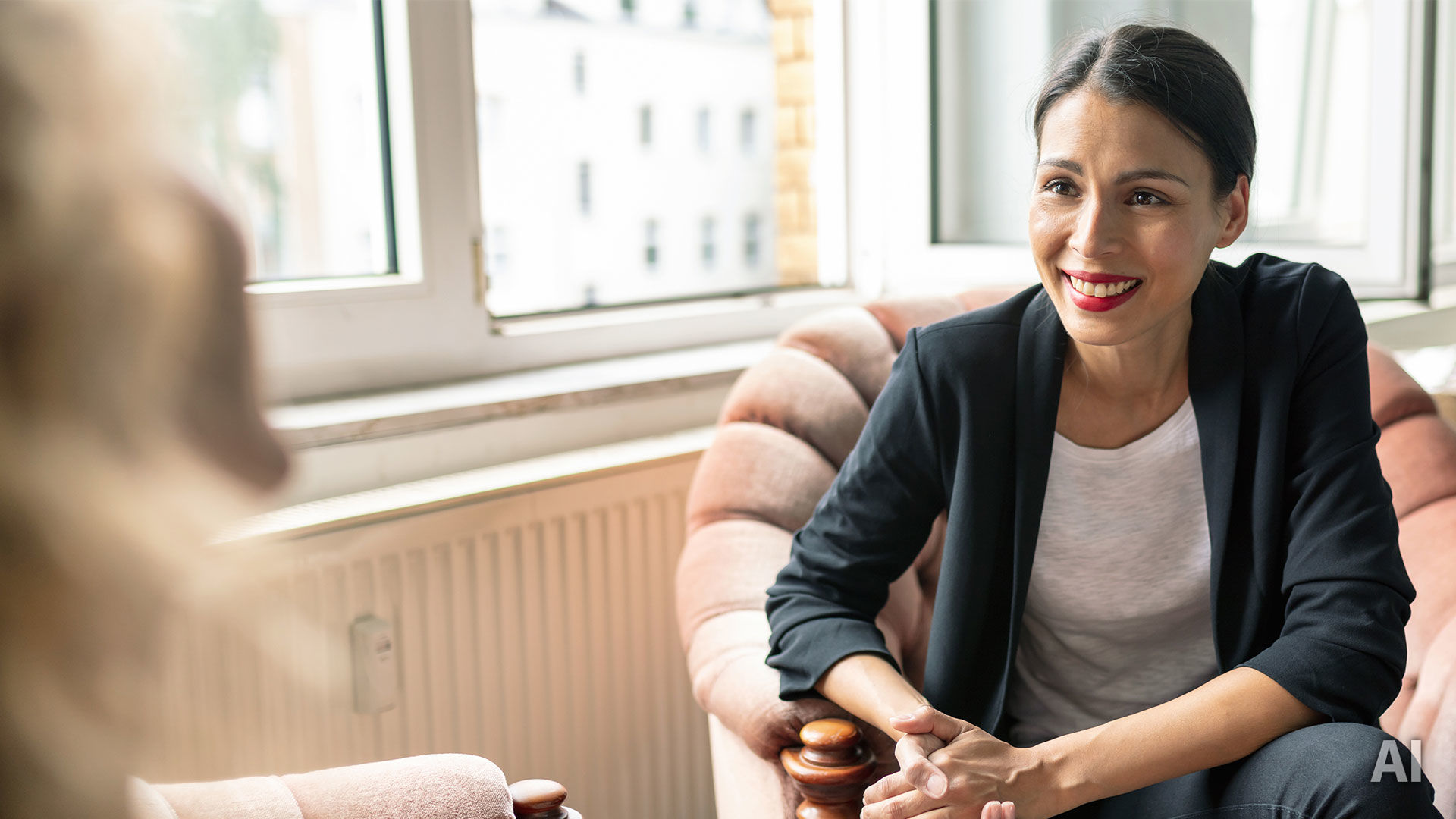 Titelbild für Artikel “Burnout”: Studentin sitzt auf einem Sessel und lässt sich zu Maßnahmen zur Vorbeugung von Burnout beraten, AI-generated