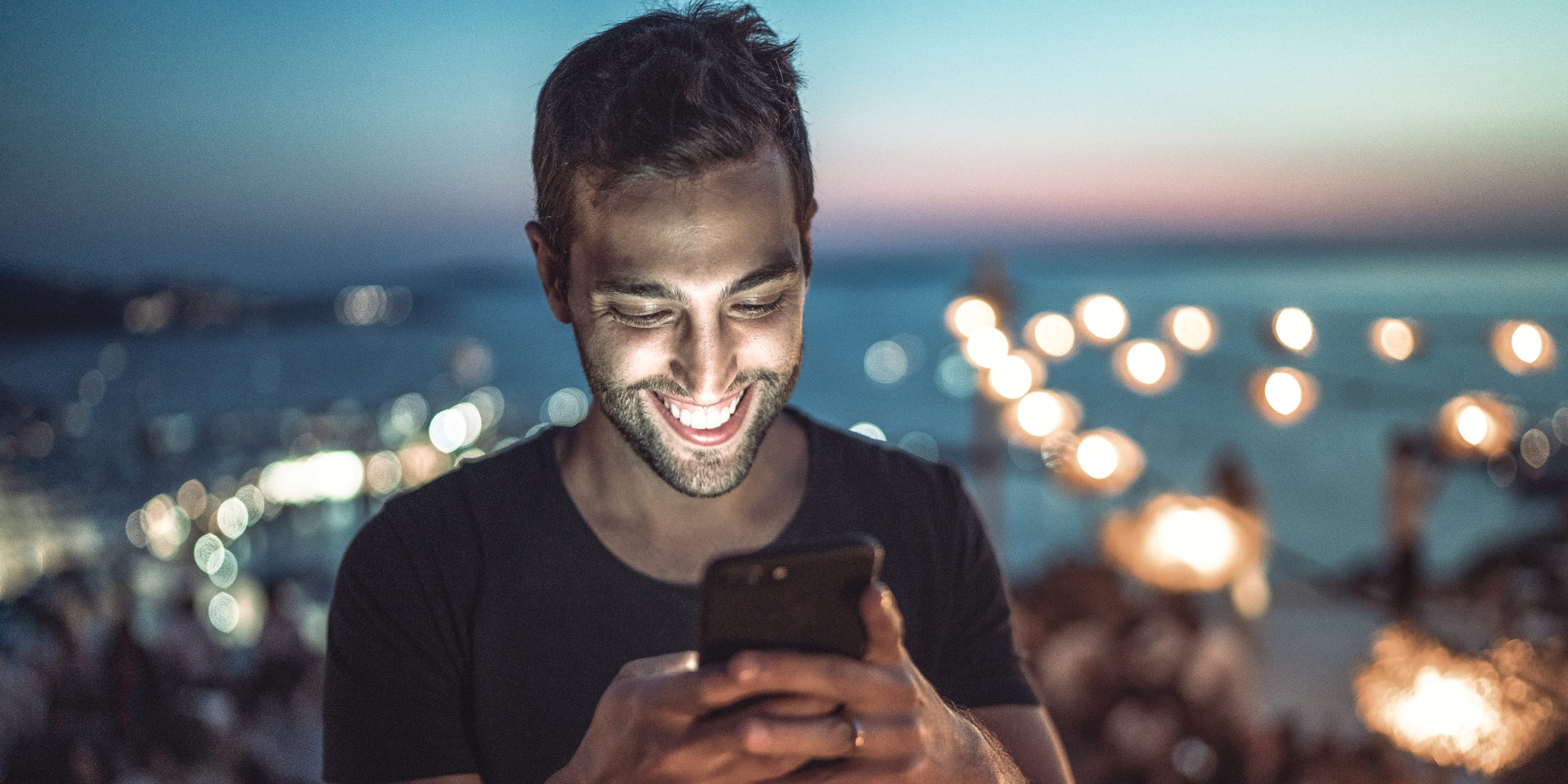 Titelbild für Infoseite “Bachelor Eventmanagement”: Eventmanager schaut auf sein Handy während eines Open-Air-Konzerts