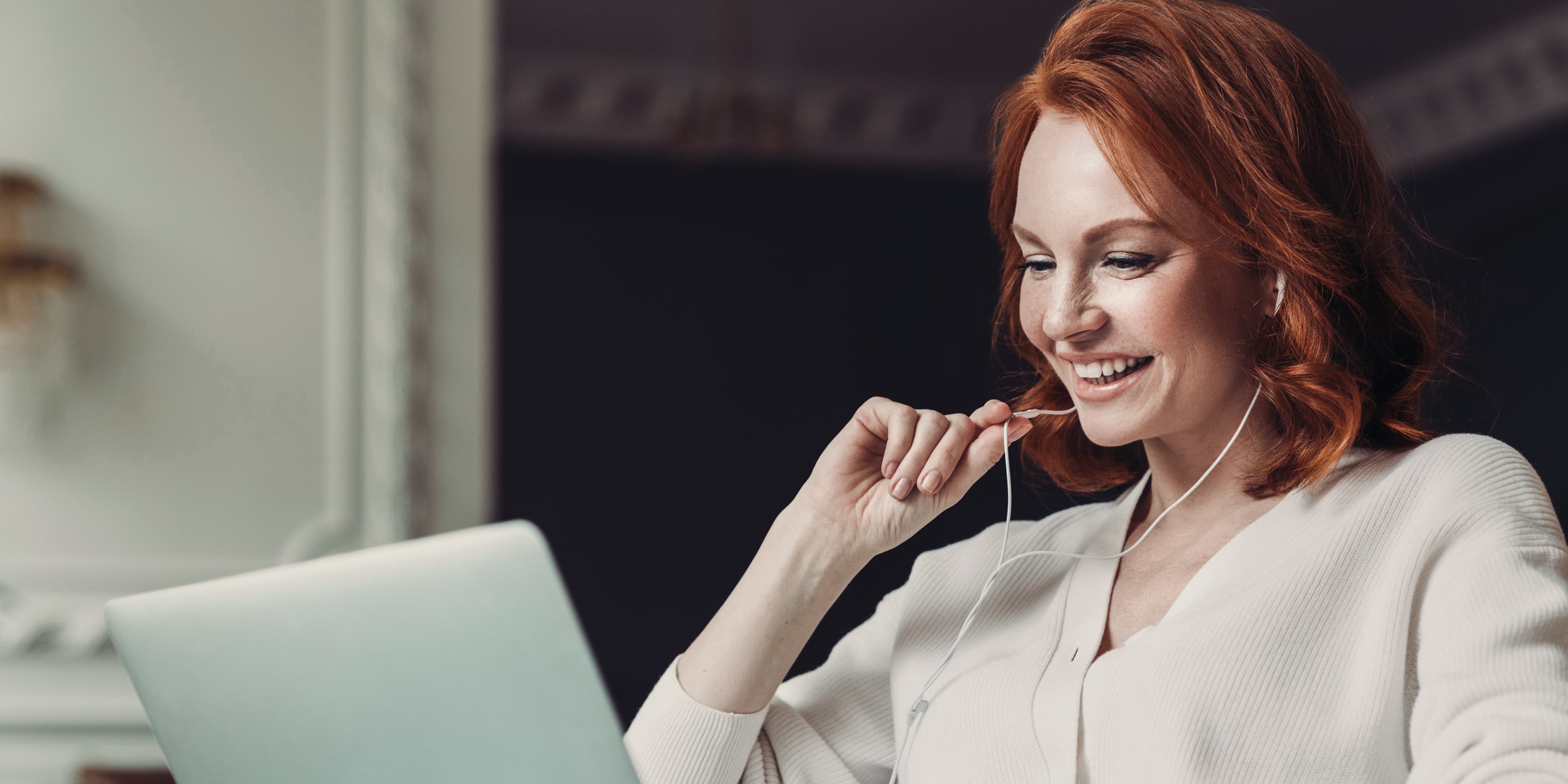 Titelbild für Infoseite “Master Marketingmanagement”: Marketing-Managerin arbeitet am Laptop mit Headset