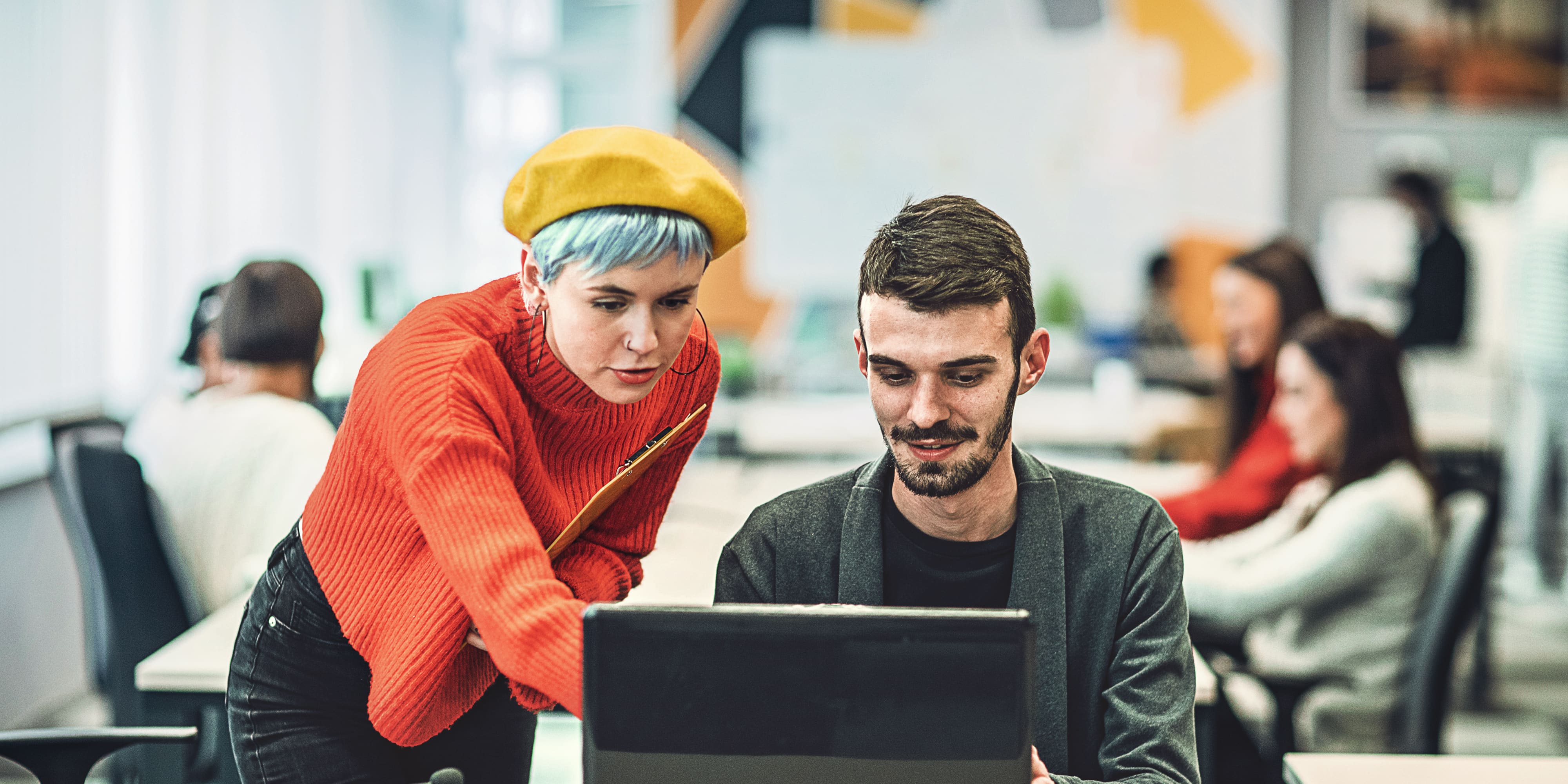 Titelbild für Infoseite “Bachelor Personalmanagement”: Zwei Personalmanager schauen zusammen auf Bildschirm