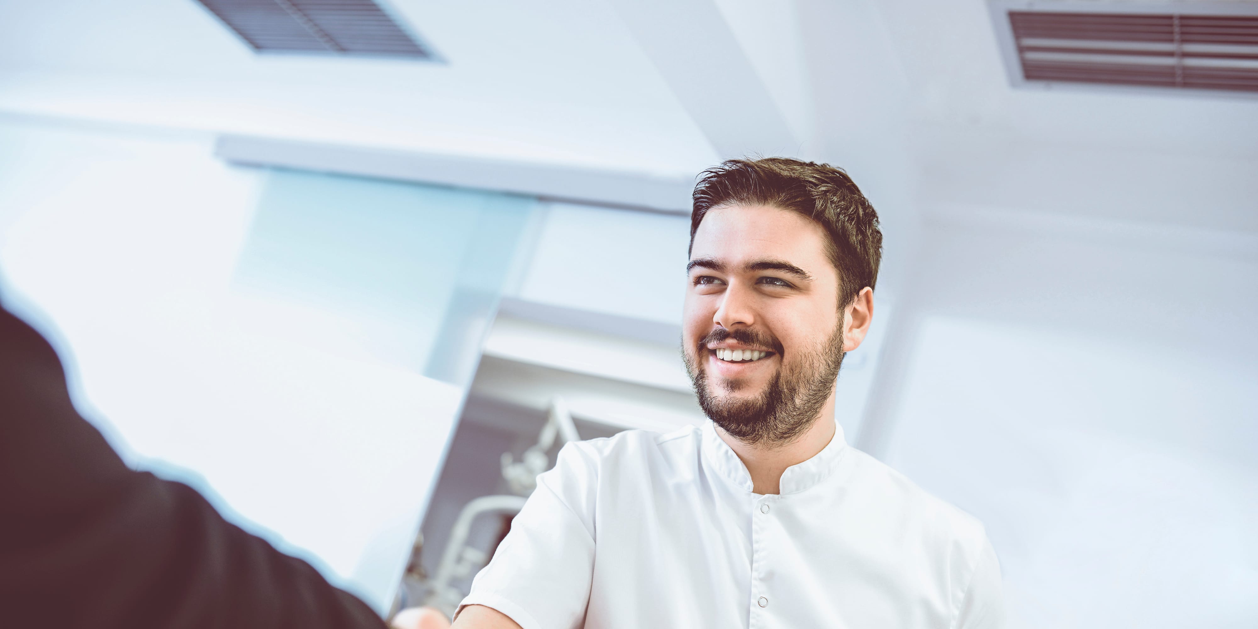 Titelbild für Infoseite “Bachelor Pflegemanagement”: Pflegemanager schüttelt Hand mit Kunden