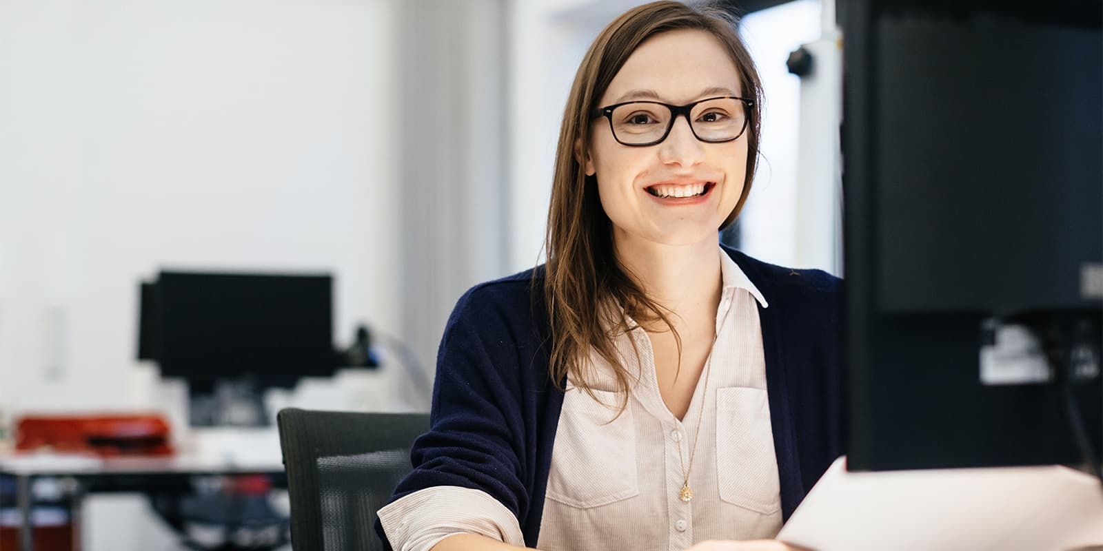 Woman smiling while working at her computer in an office