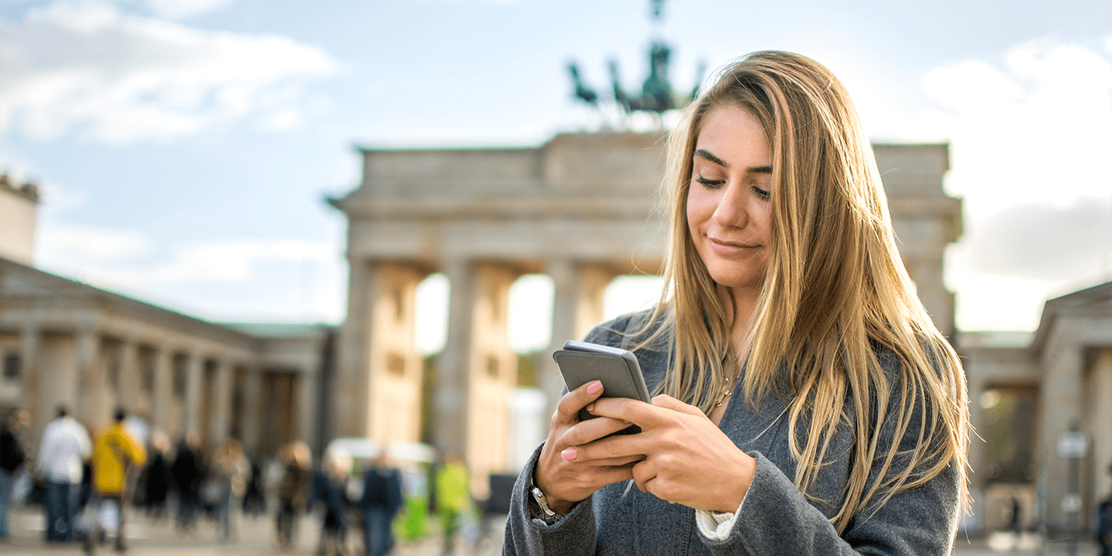 Young student happy in Berlin using her phone