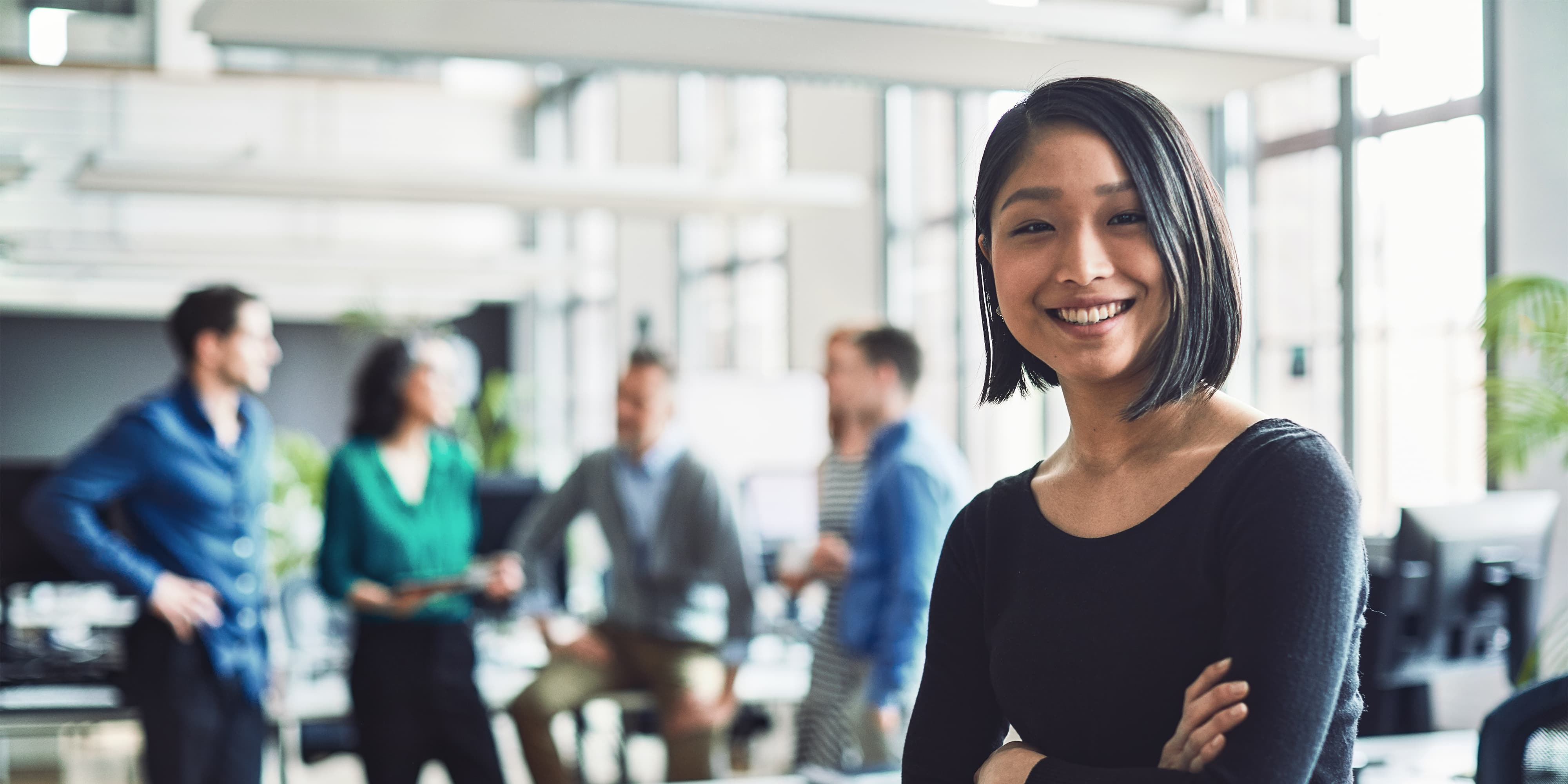 Titelbild für Infoseite “MBA - Human Resource Management”: HR Managerin steht in Großraumbüro