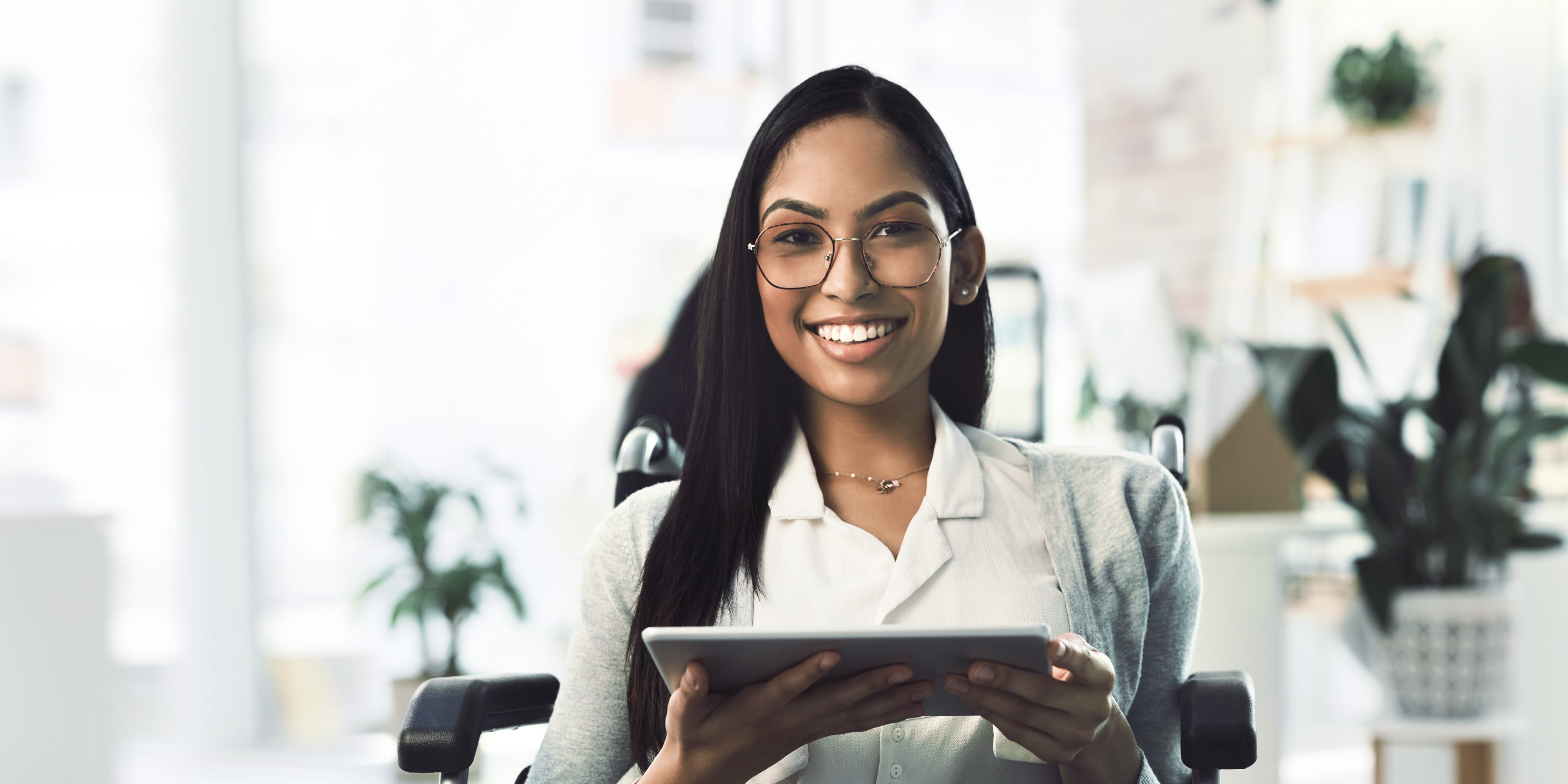 Titelbild für Studiengangseite "myStudium Betriebswirtschaftslehre": Frau in Büro mit Tablet in der Hand
