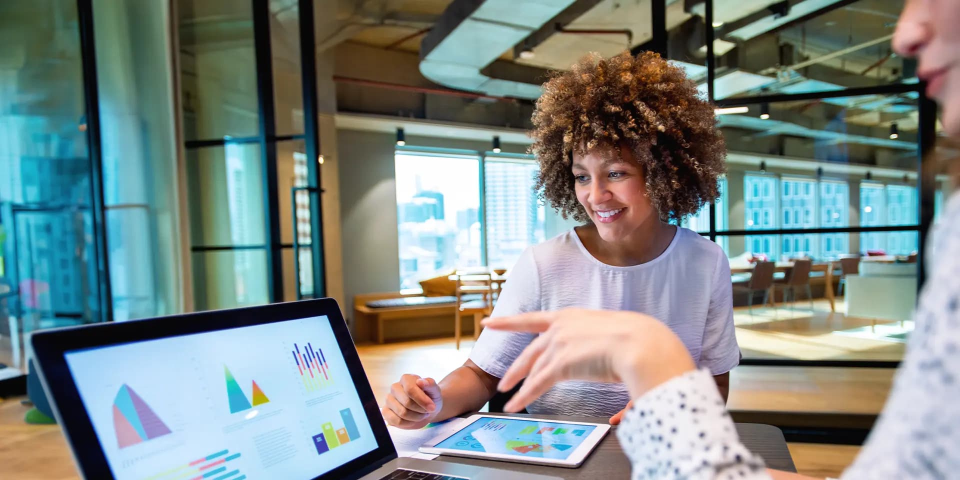 Titelbild für den Artikel "Was ist quantitative Forschung?": Zwei Personen schauen auf einen Laptop mit Grafiken