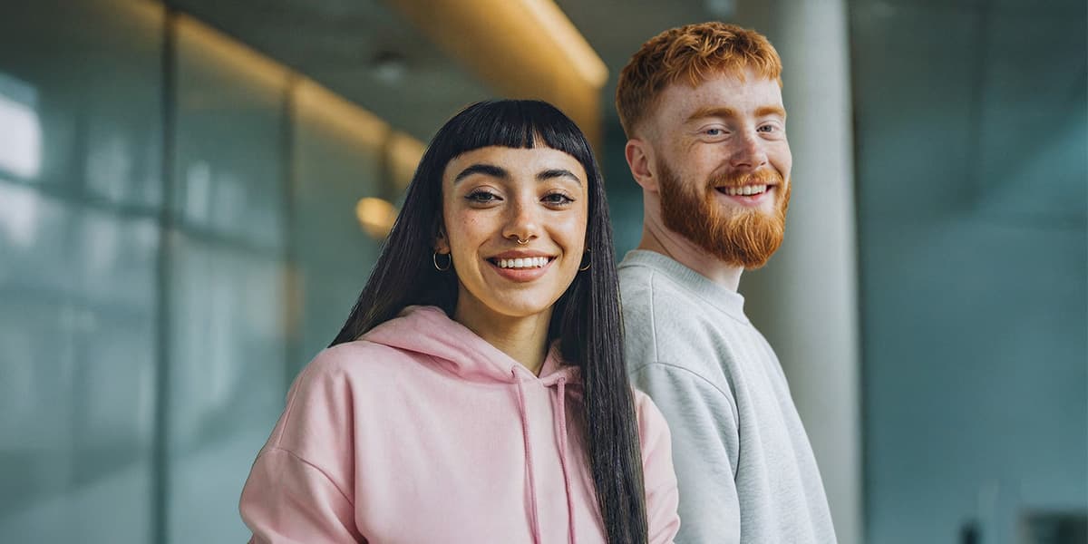 Duales Studium an der IU Internationalen Hochschule: Zwei Studierende vor dem Campus