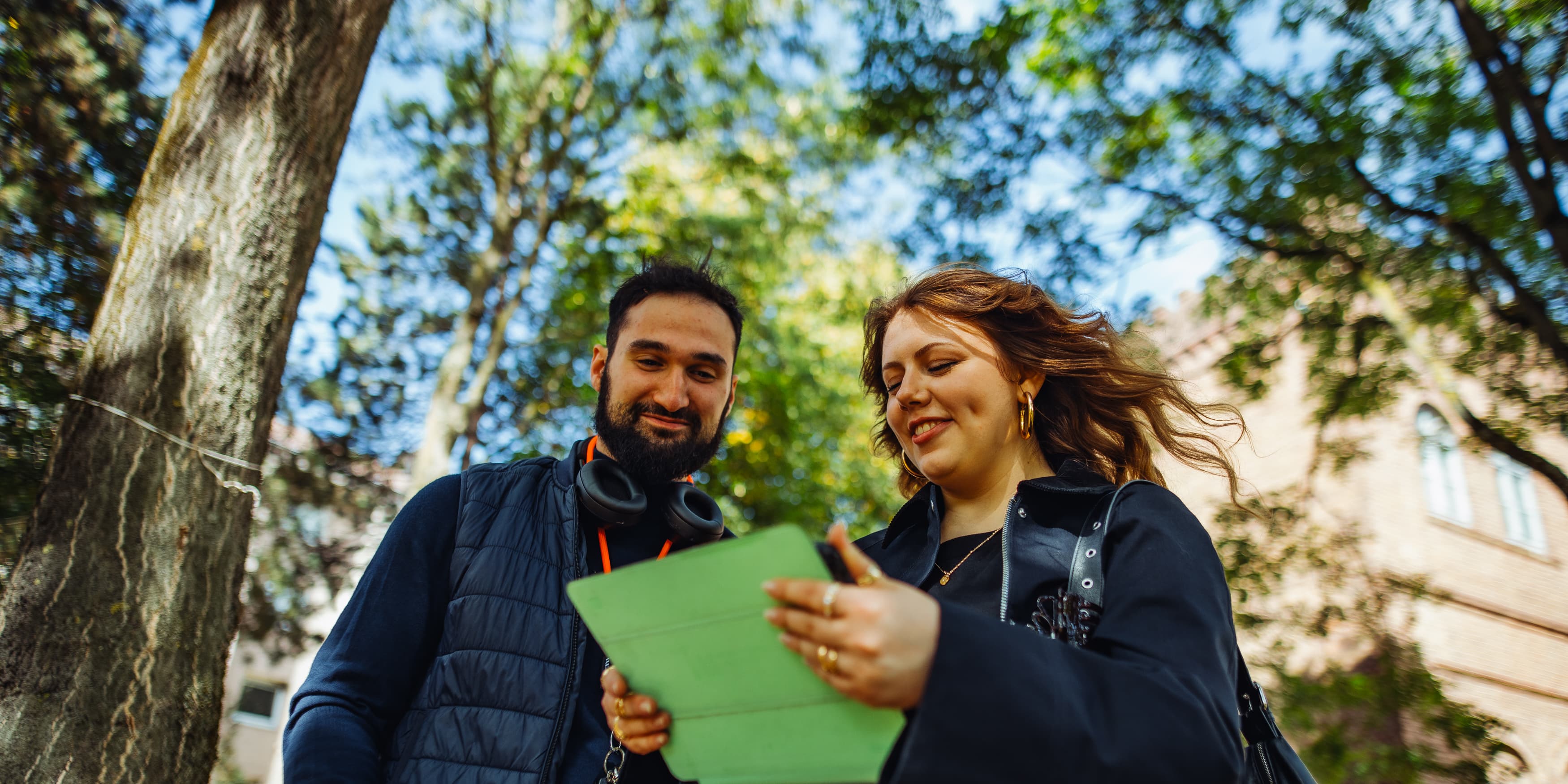 A pair of IU students checking some notes on an tablet while enjoying the nature