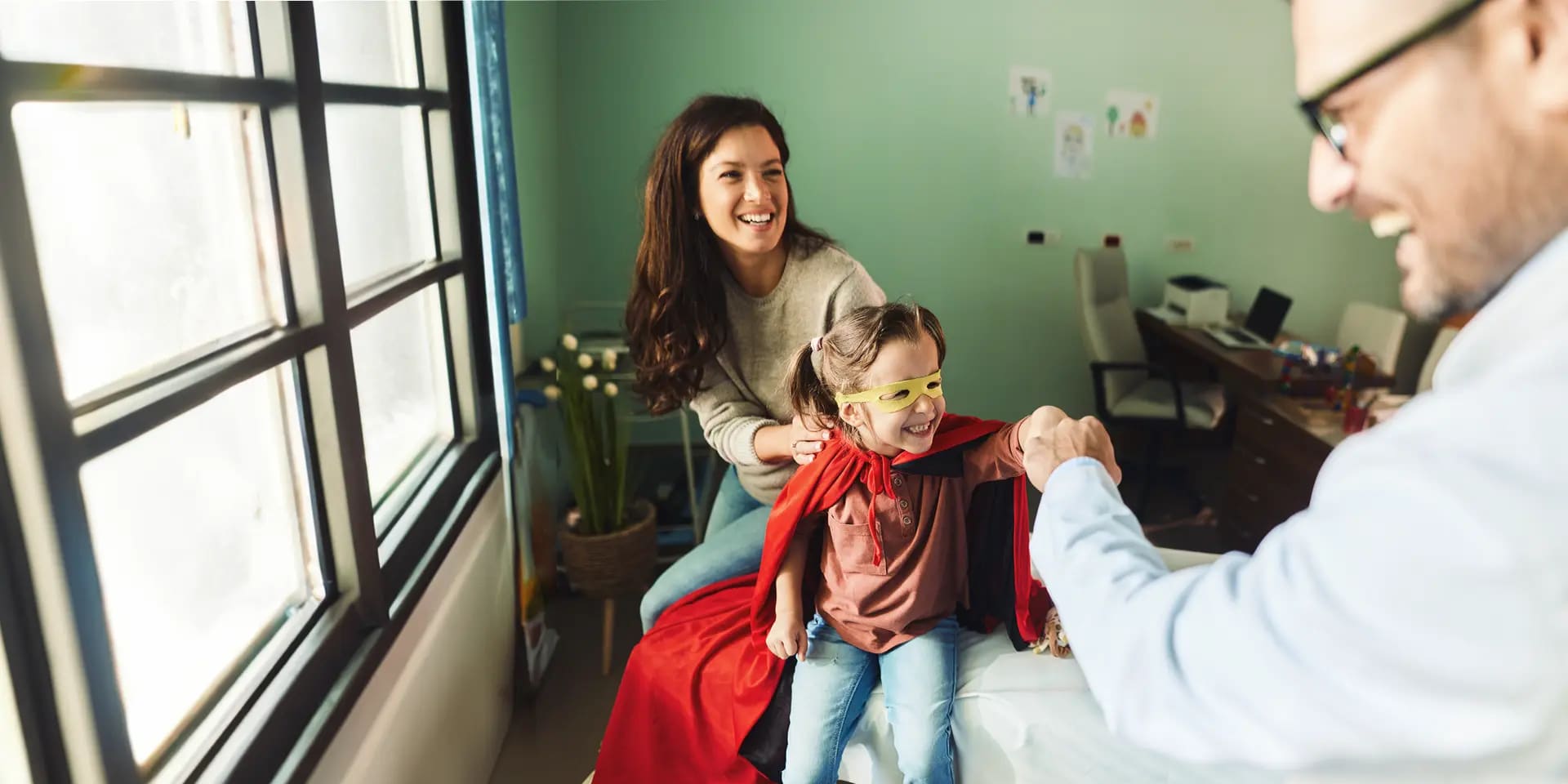 Berufe mit Kindern: Pädagoge unterhält sich mit Kind und Mutter