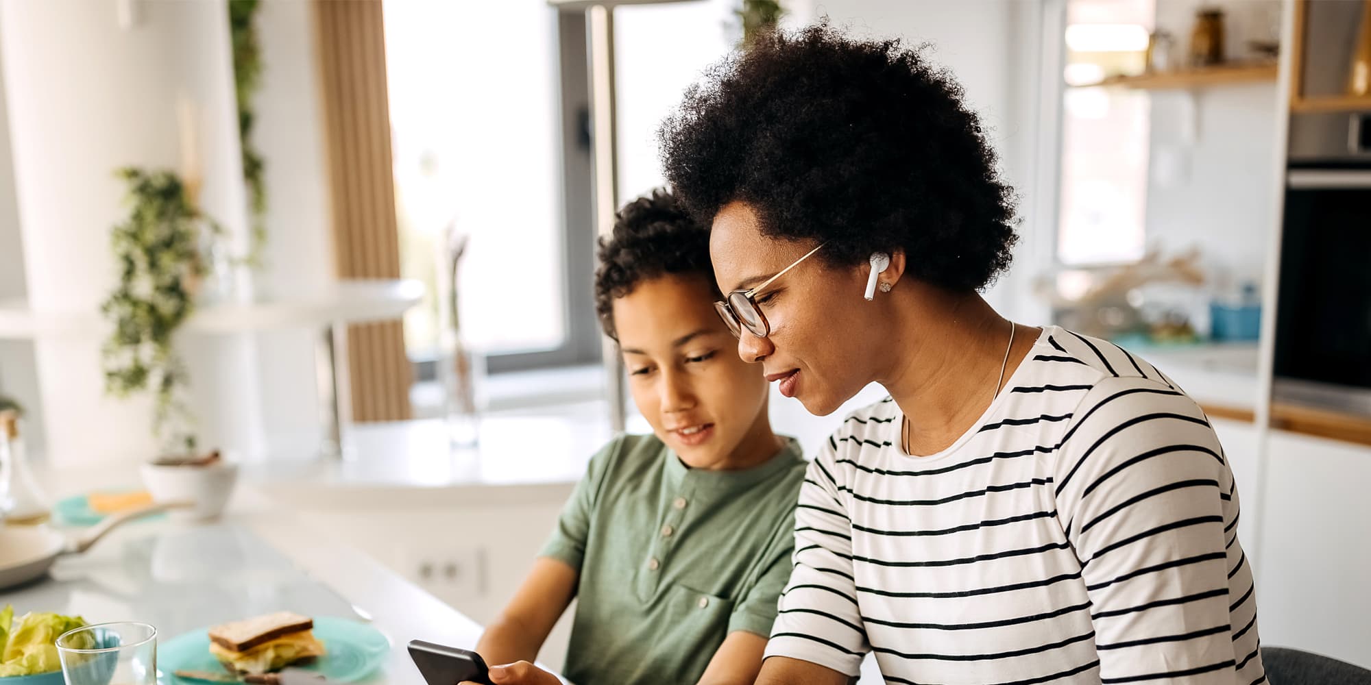 Titelbild für Infoseite “flexibel studieren”: Studentin mit Sohn, während sie am Laptop arbeitet