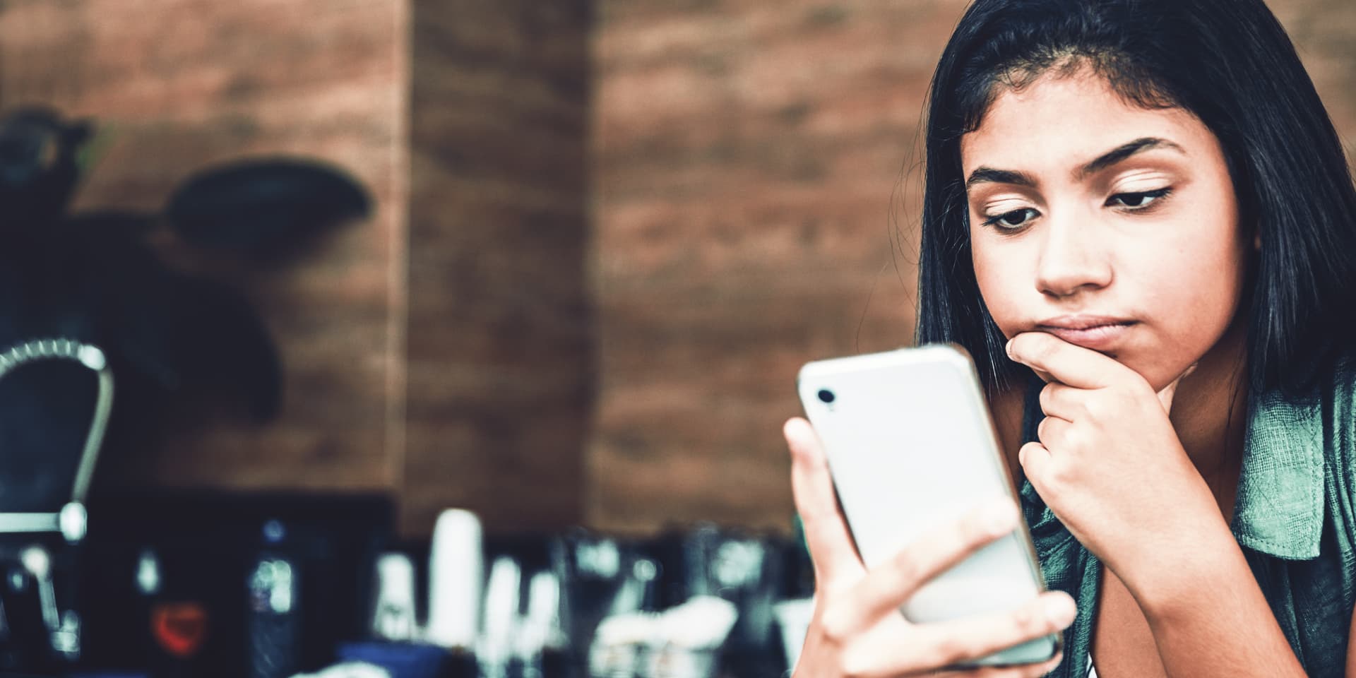 Titelbild zum Artikel "Ghosting": Frau schaut frustriert auf ihr Smartphone