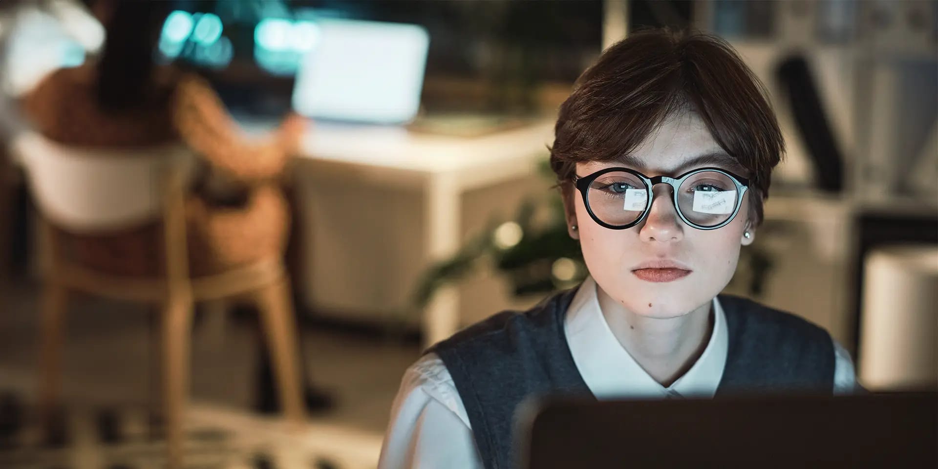 Titelbild zum Artikel "Konzentration steigern": Studentin mit Brille arbeitet konzentriert am Laptop